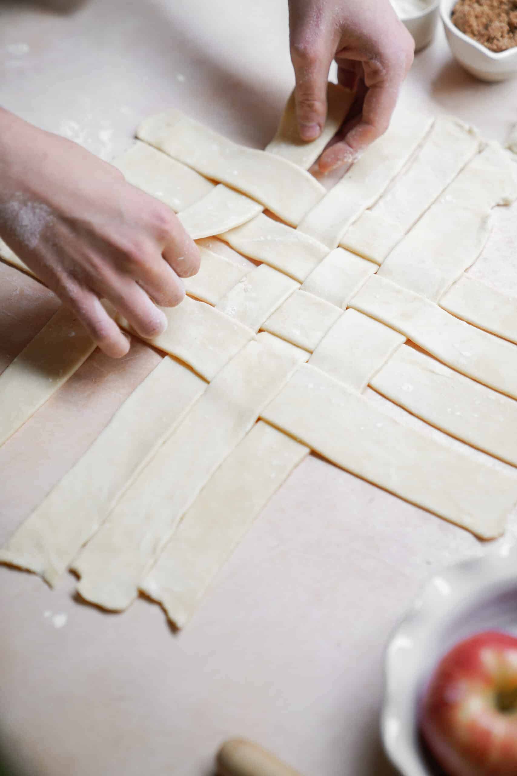 Dough being weaved for top of apple pie