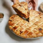 Homemade apple pie with a piece being lifted out of it