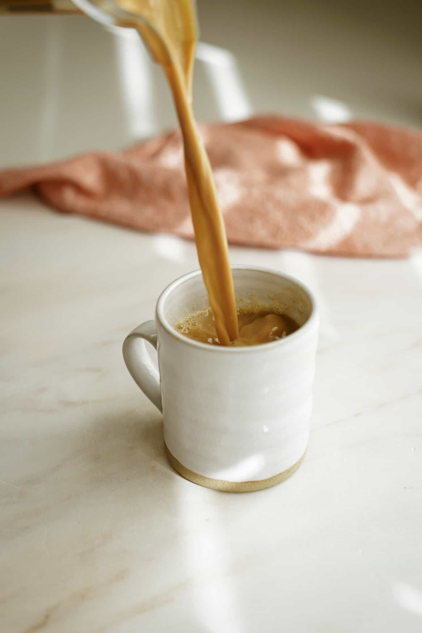 Pumpkin spice latte being poured into a mug