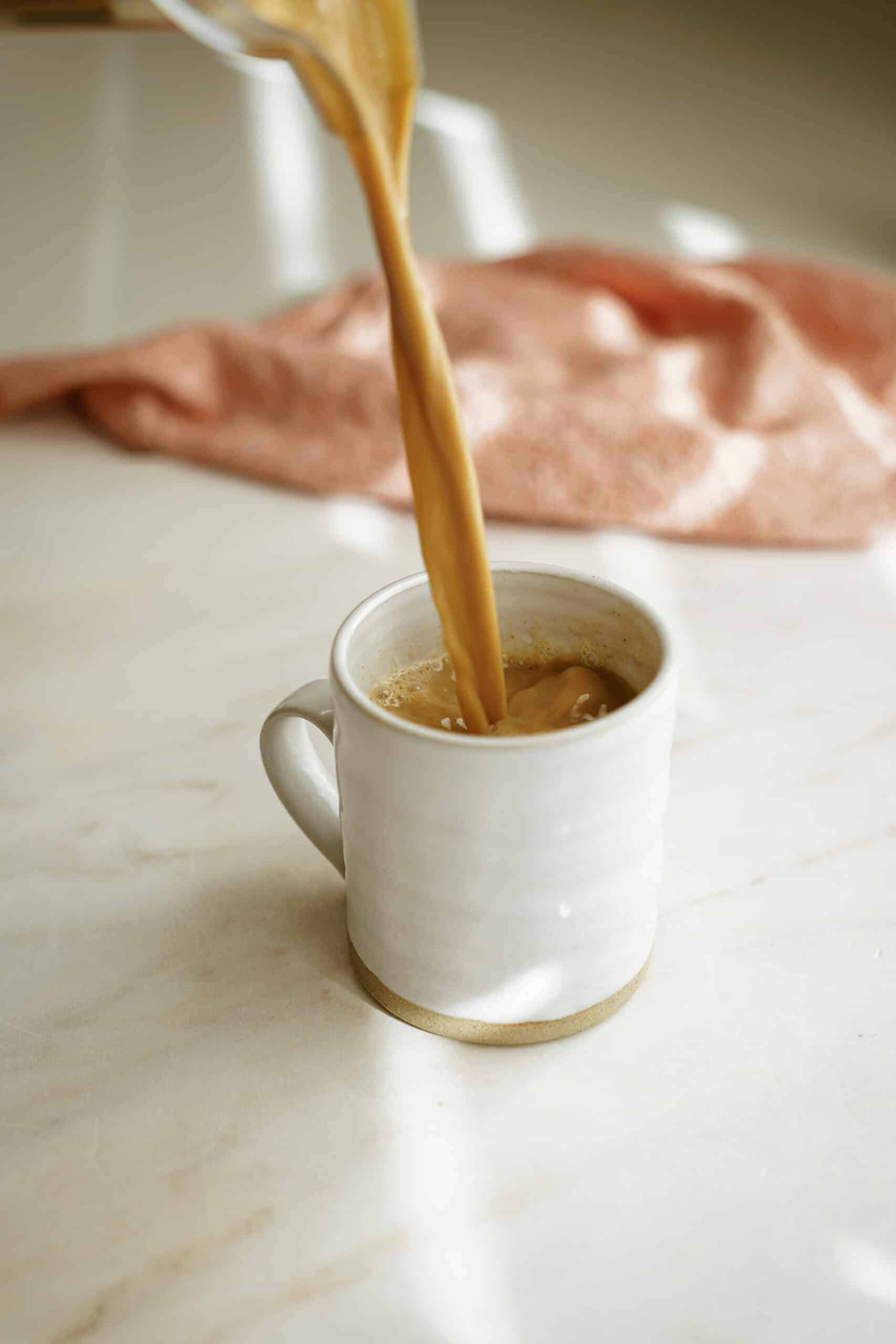 Pumpkin spice latte being poured into a mug