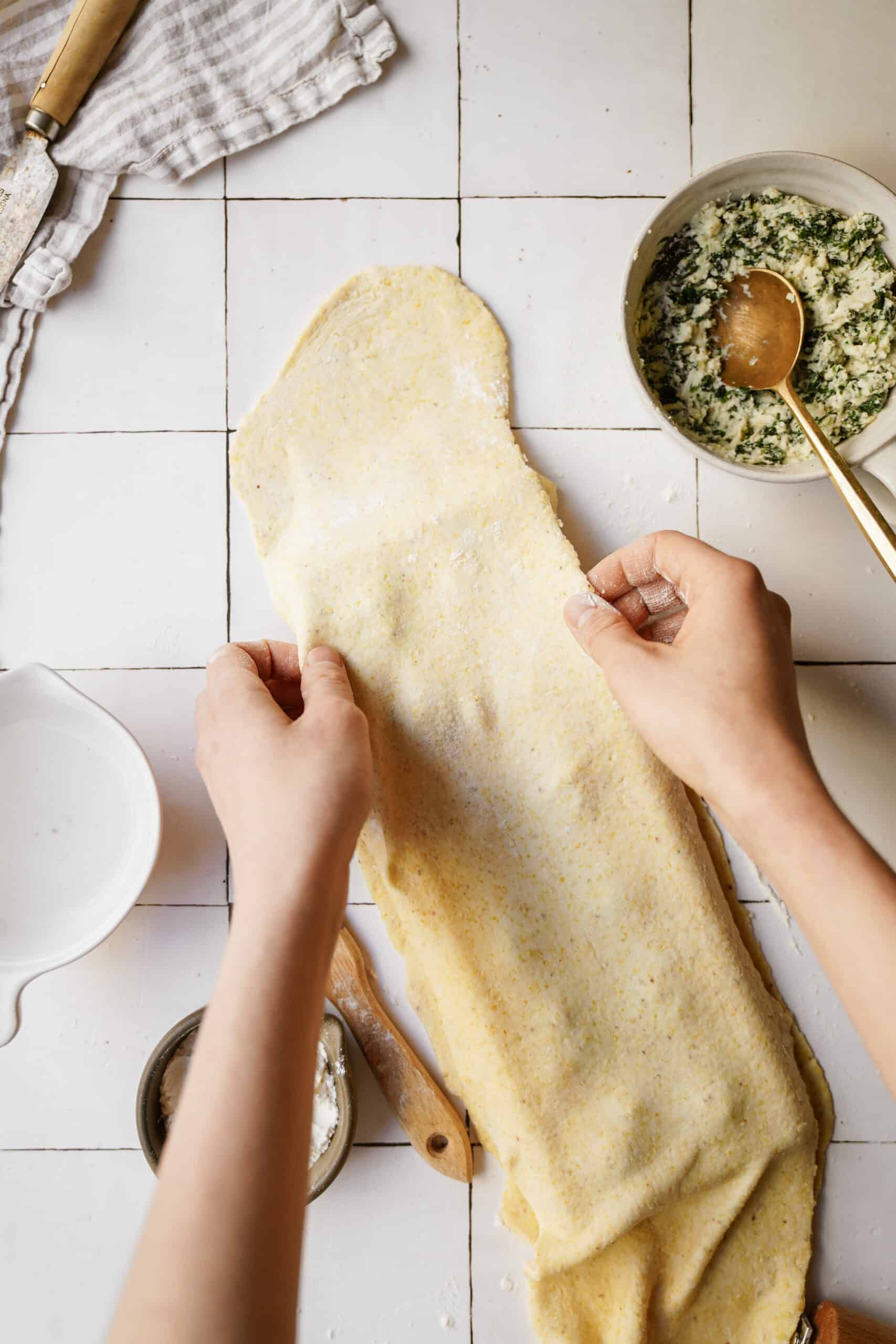 Dough being laid ontop of ravioli maker for Spinach and Ricotta Ravioli