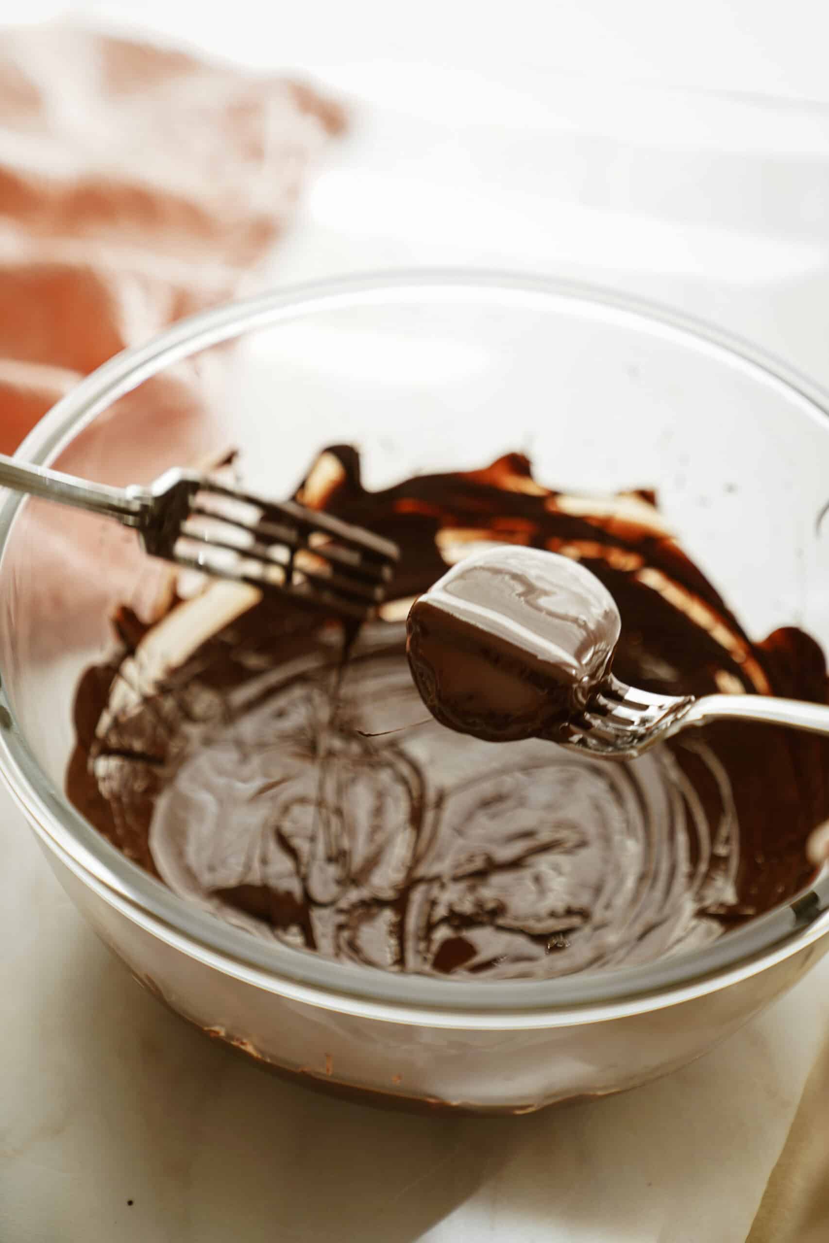 Homemade Reese's Eggs being dipped in a bowl of chocolate