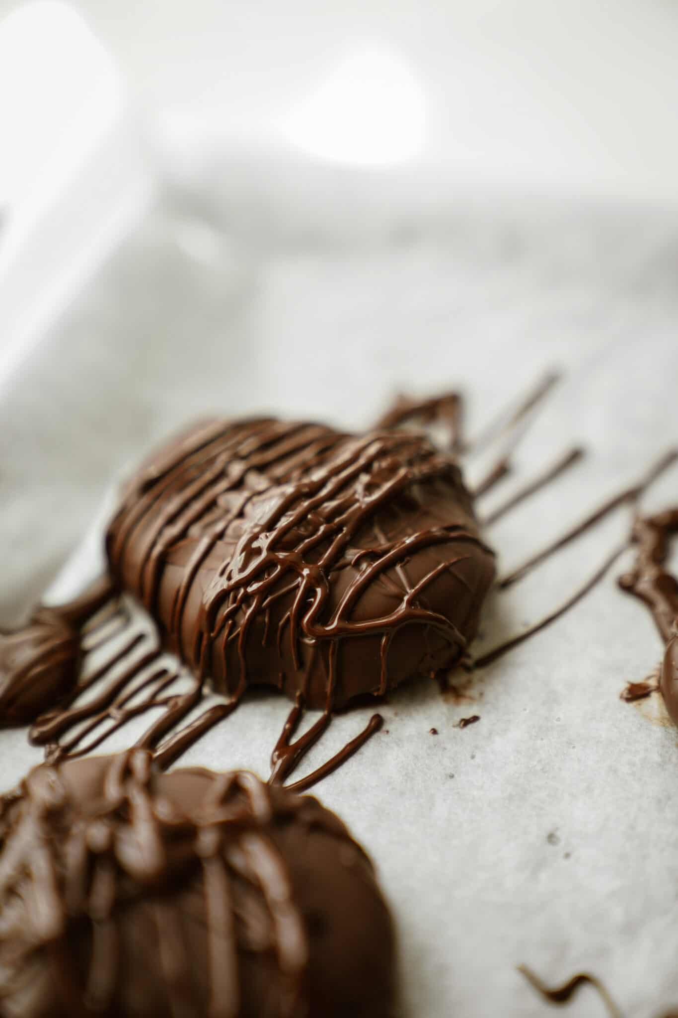 Homemade Reese's Eggs on a tray with drizzles of chocolate on them