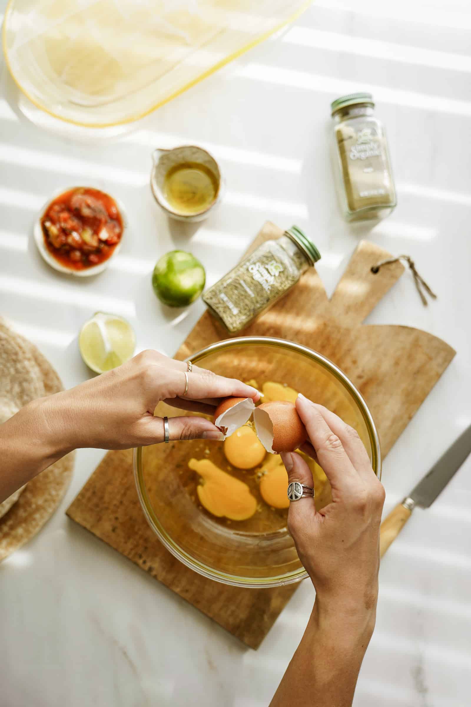 Eggs added to a mixing bowl for vegetarian breakfast burritos