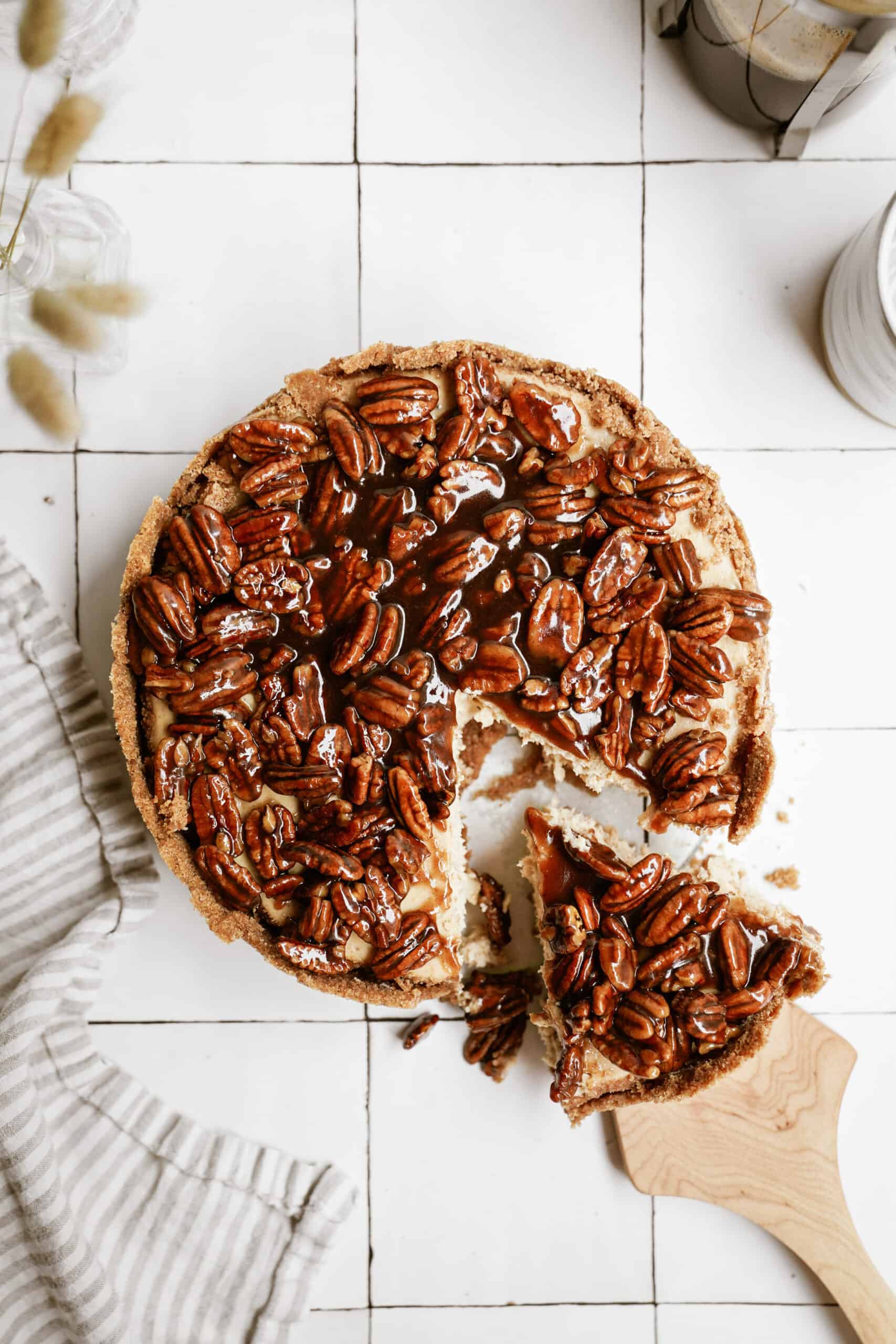 Pecan pie cheesecake recipe with a slice being taken out of it