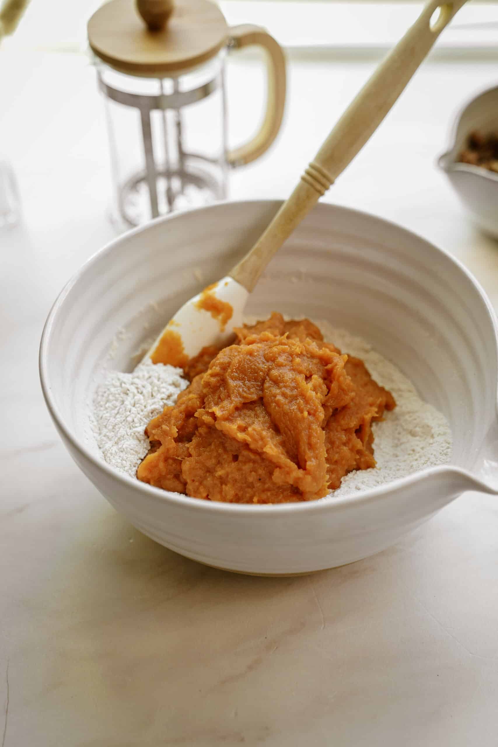 Wet and dry ingredients for sweet potato muffins mixed in a bowl