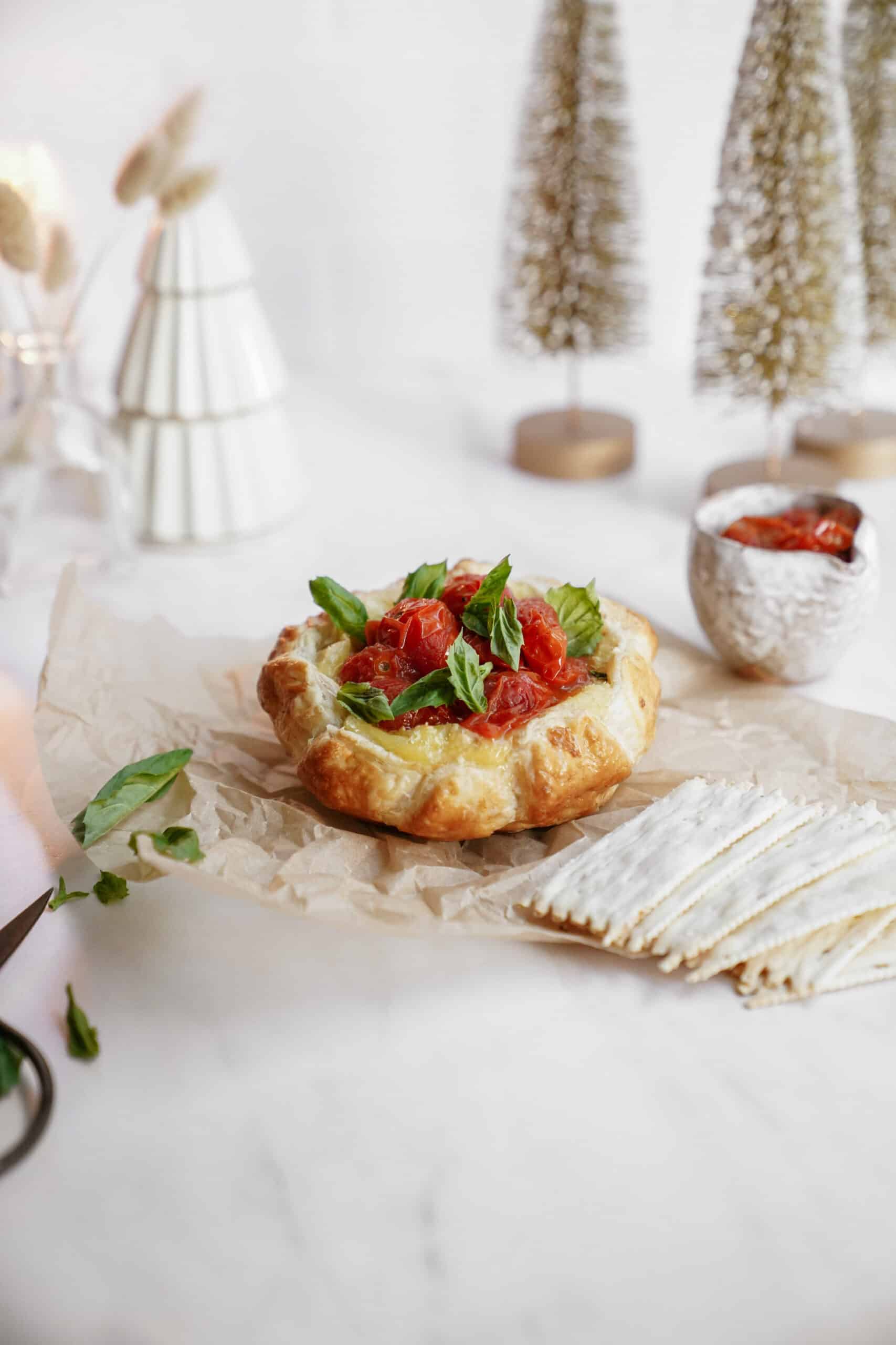 Baked brie recipe on a counter surrounded by holiday decor