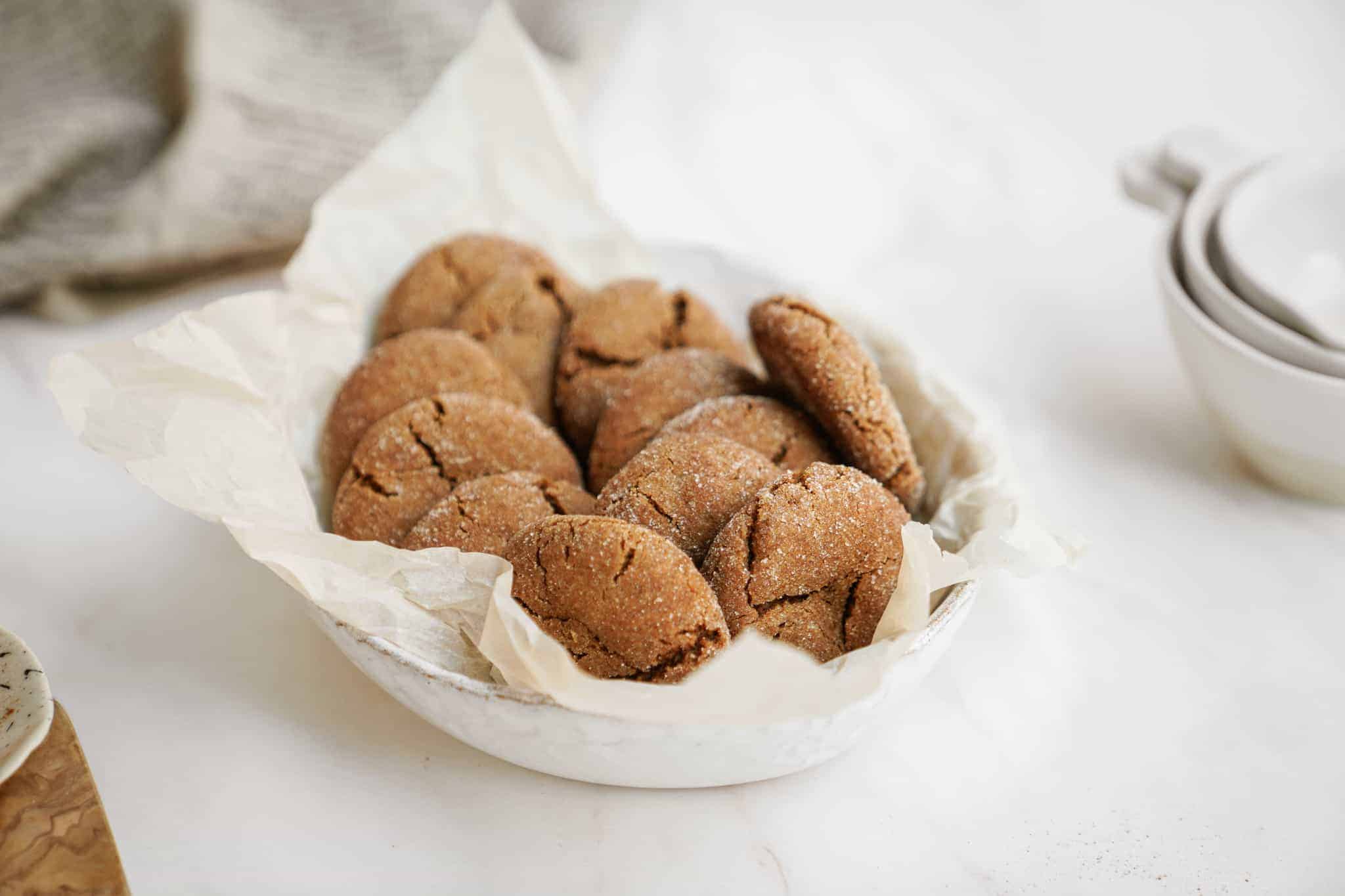 Ginger snap cookies in a basket on a white counter