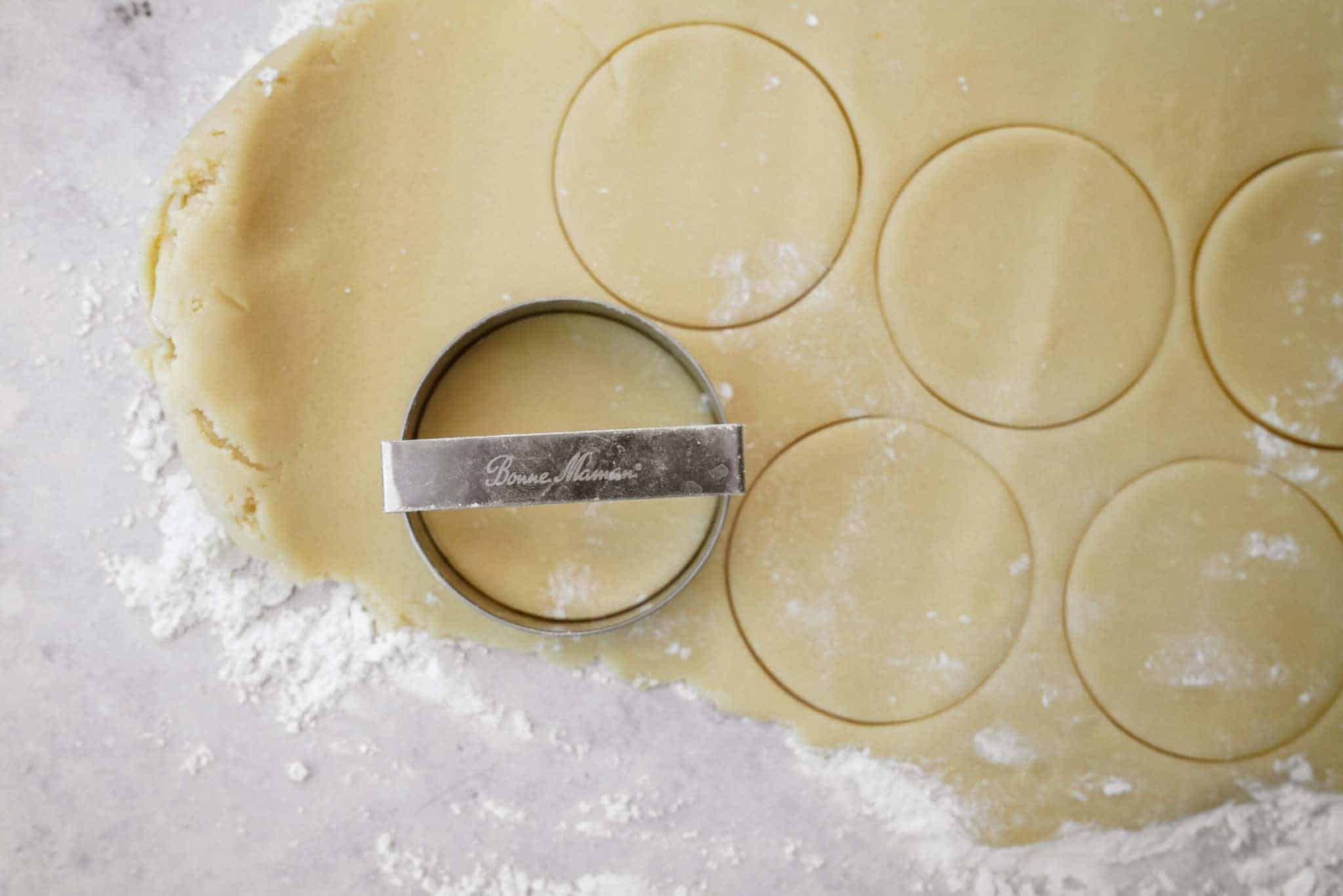 Cookie dough being cut with cookie cutter