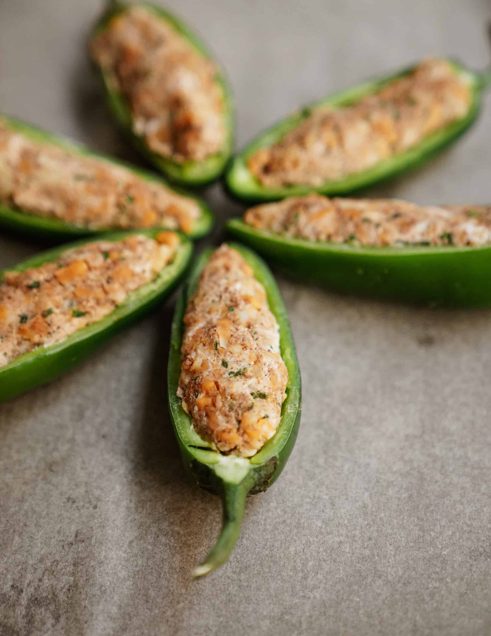 My tips on how to make jalapeno poppers with five stuffed peppers on a baking tray