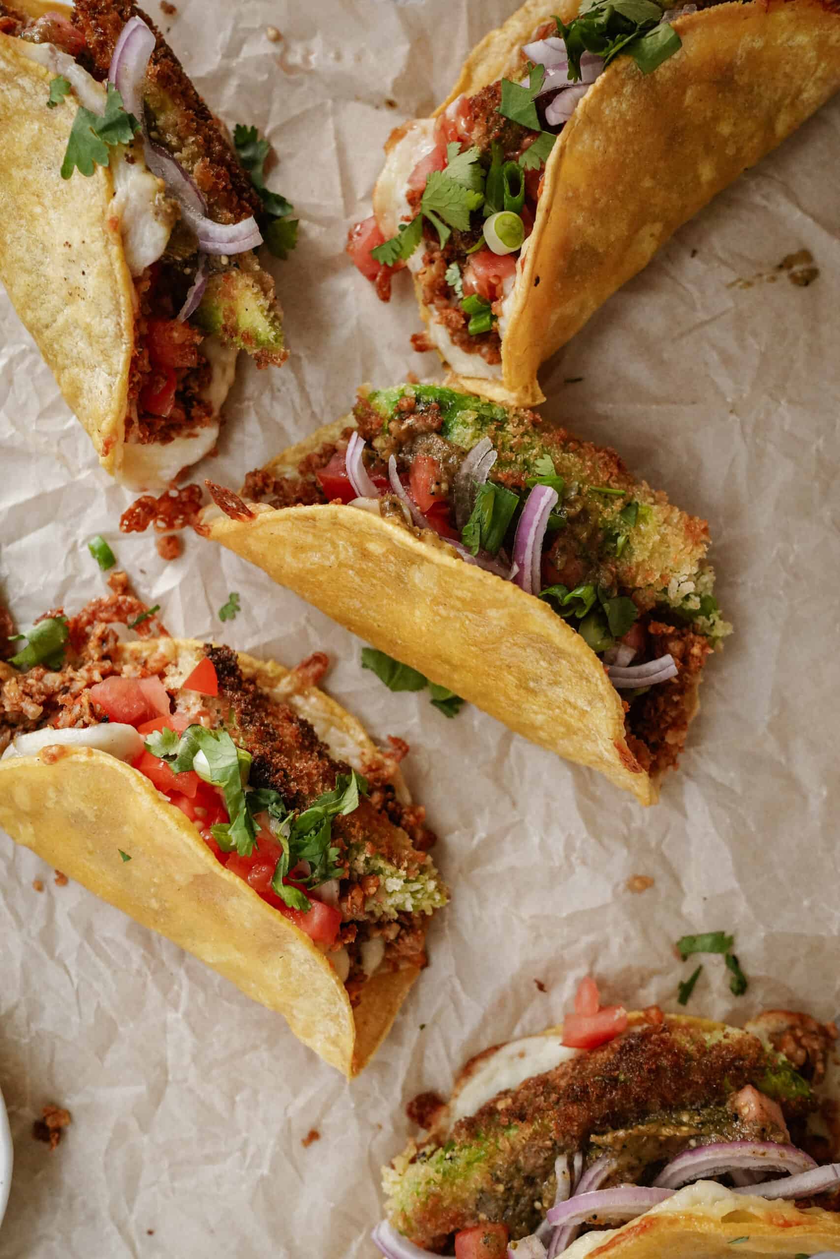 Oven baked tacos laying on parchment paper 