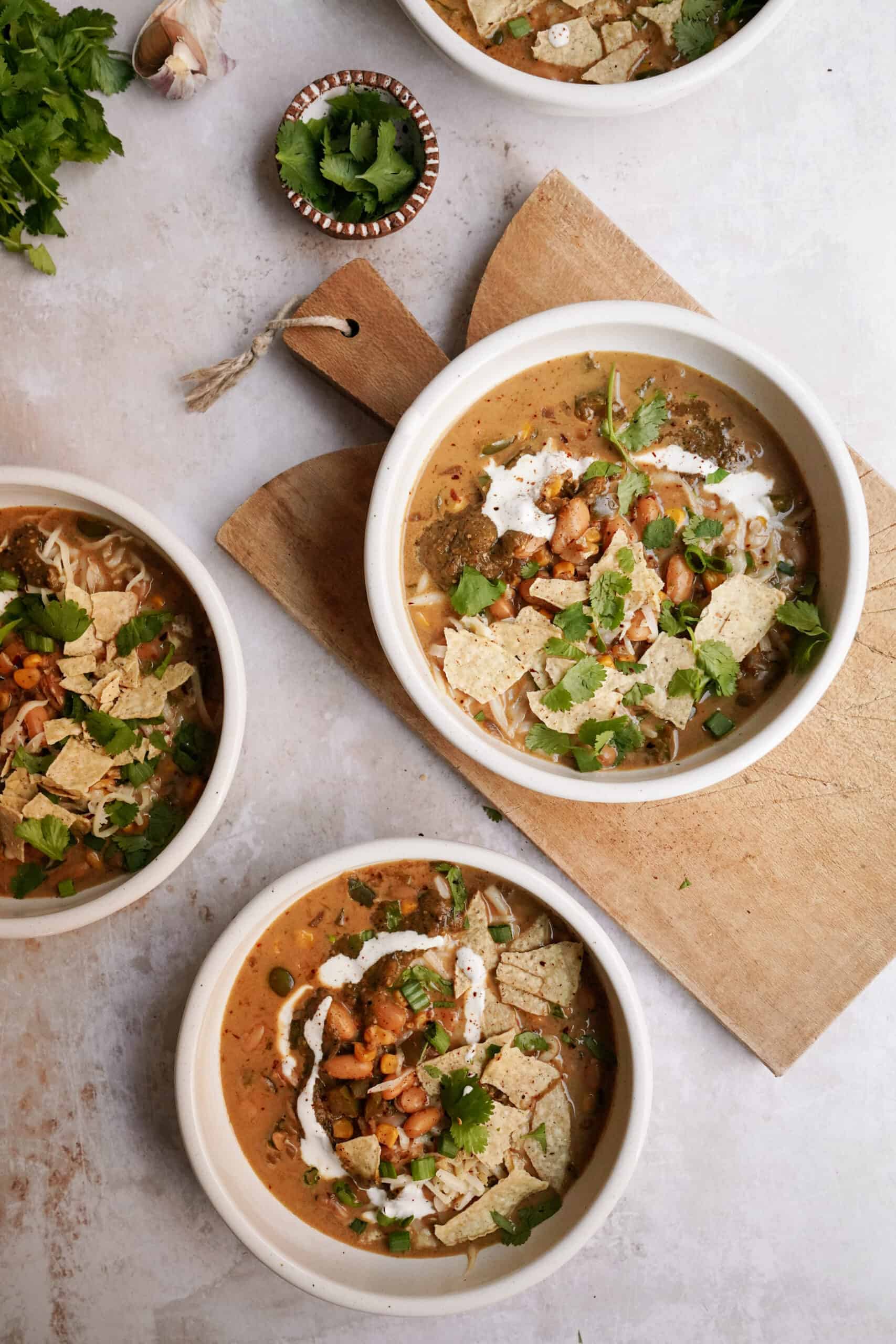 Bowls of tortilla soup on a cutting board