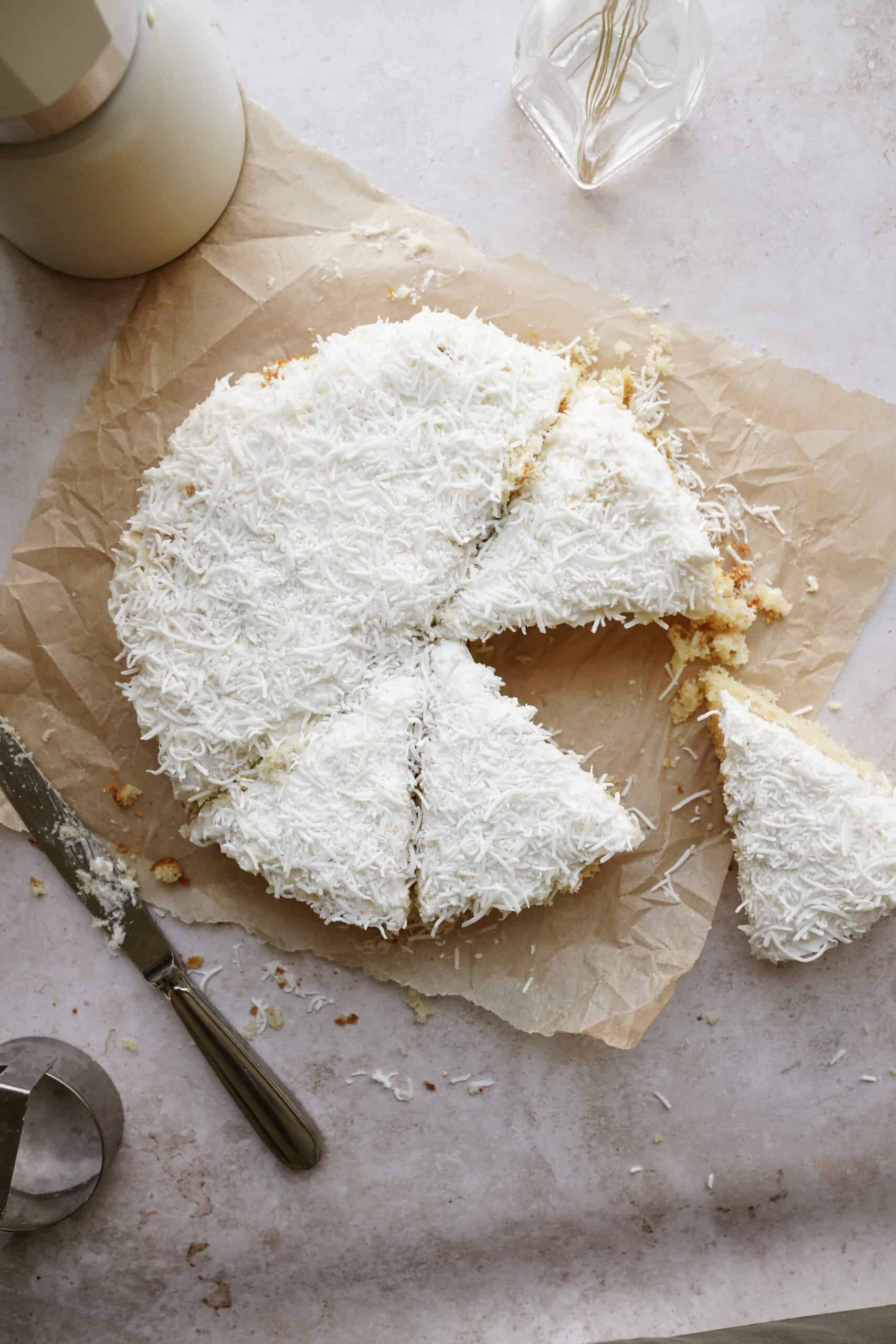 Vanilla cake on counter with slice out of it