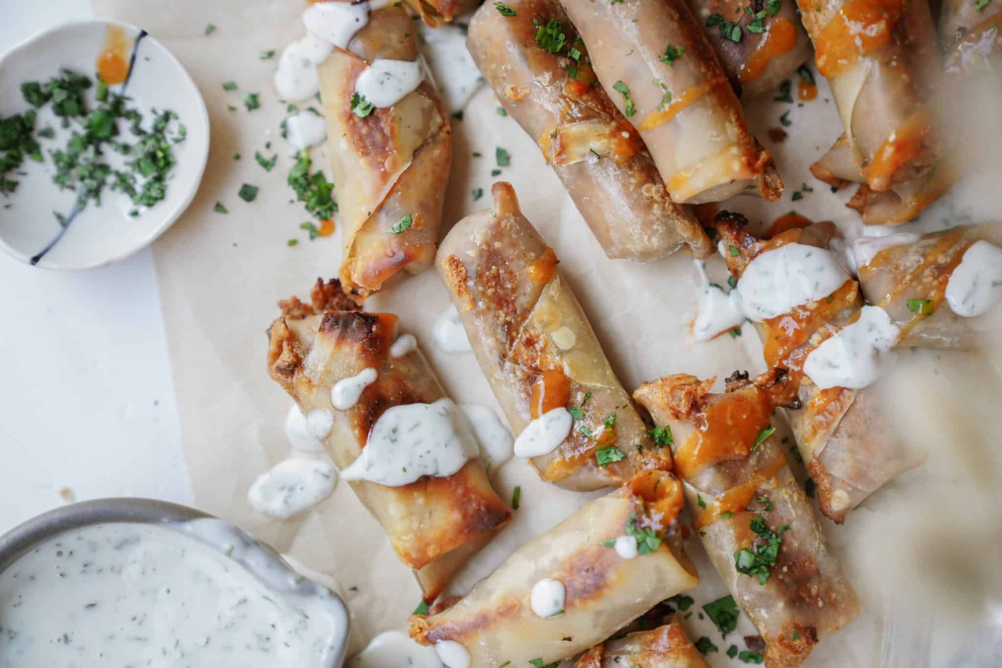 Egg roll recipe on countertop drizzled with ranch sauce