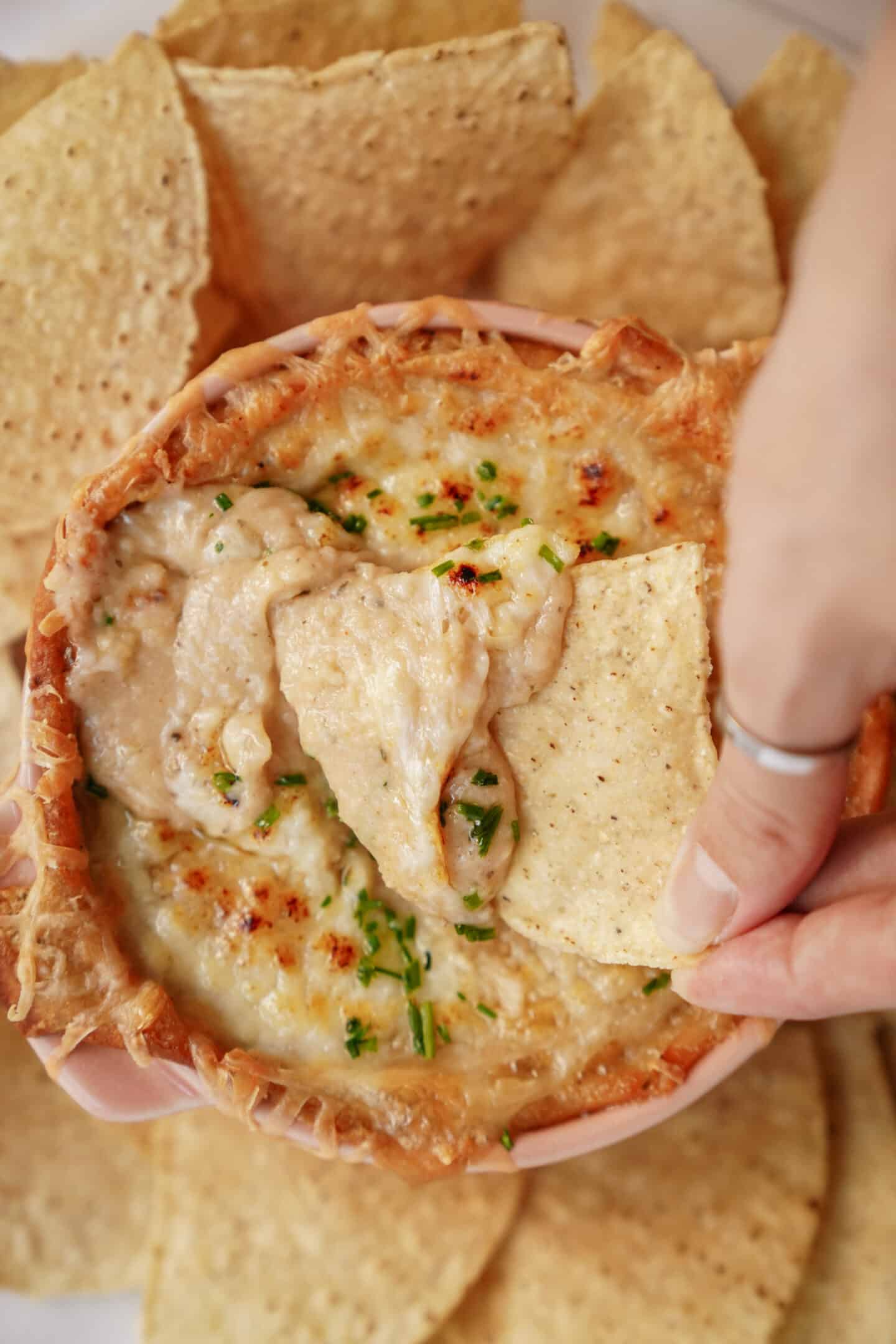 White Bean Dip being dipped with a nacho chip