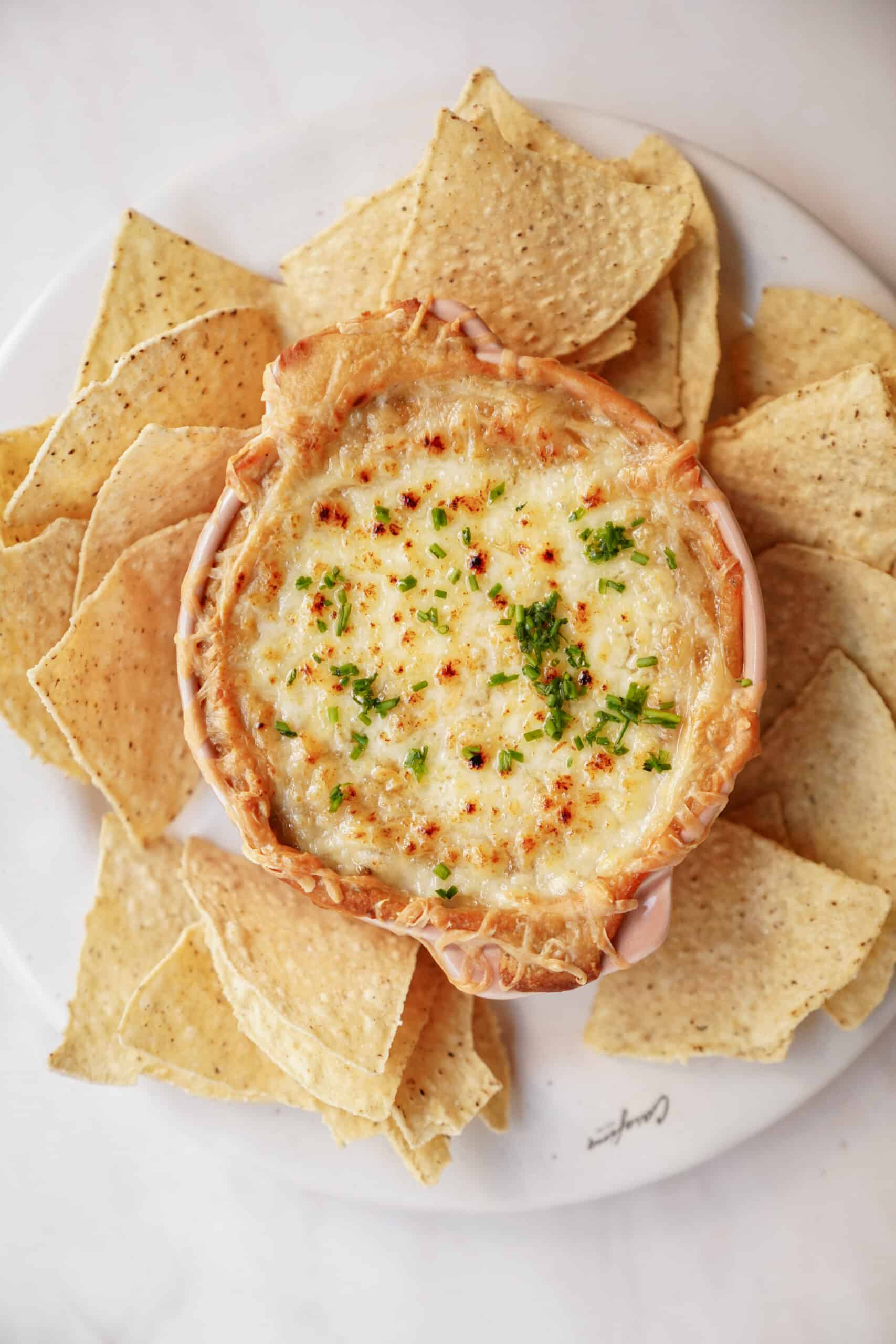 White Bean Dip surrounded with nacho chips on a plate