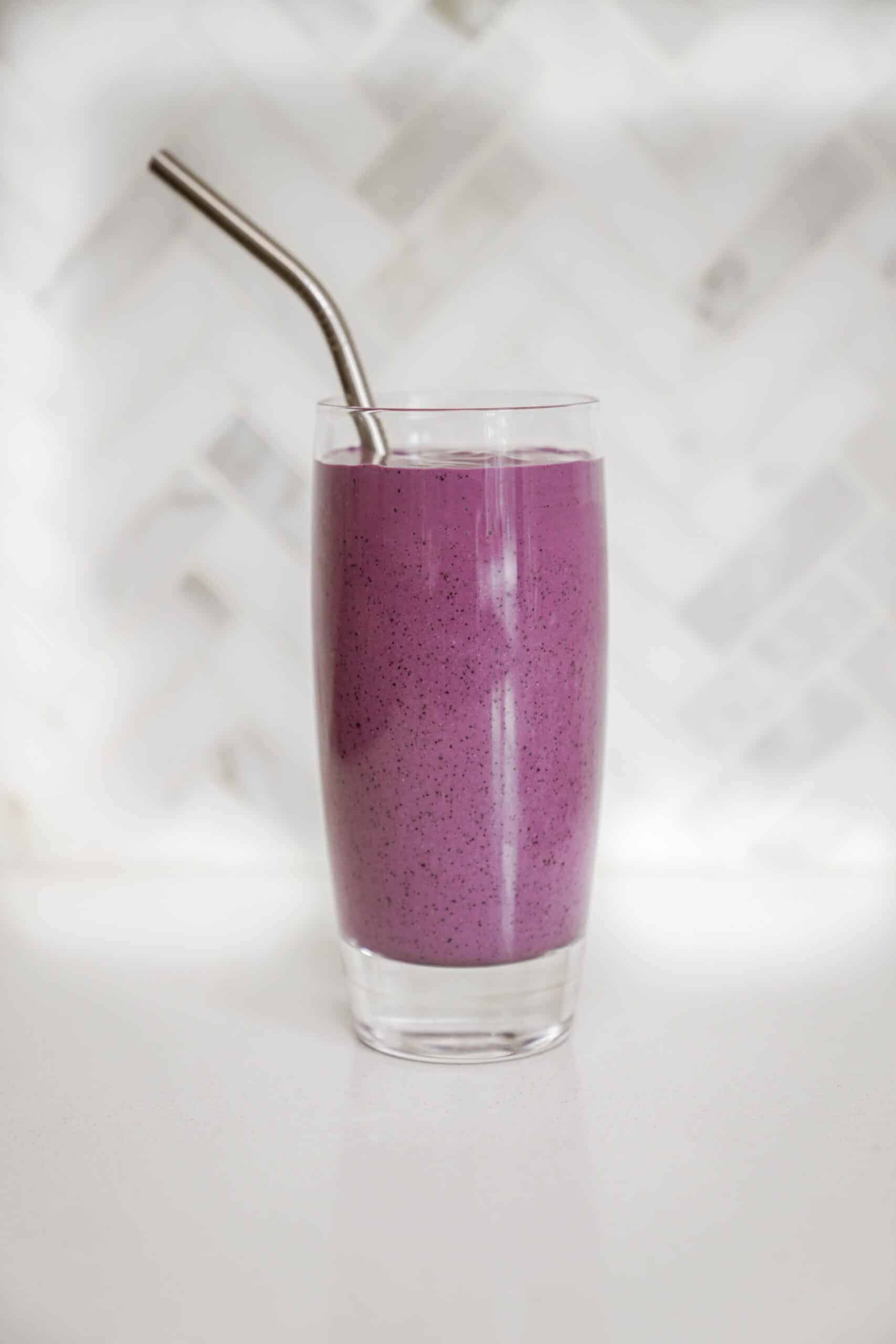 Cheesecake smoothie in a glass with a straw