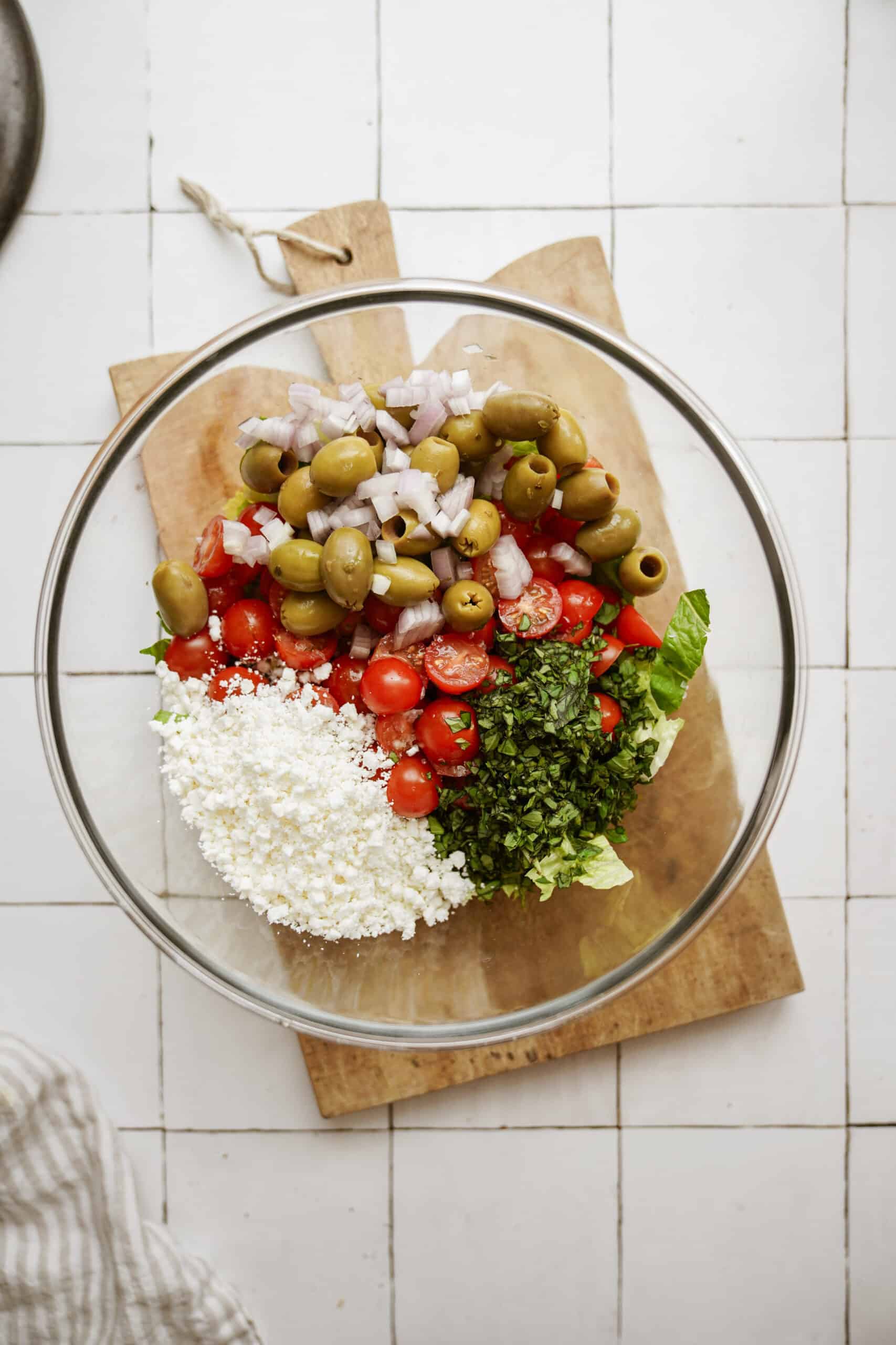 Raw ingredients for cobb salad in a bowl on a cutting board