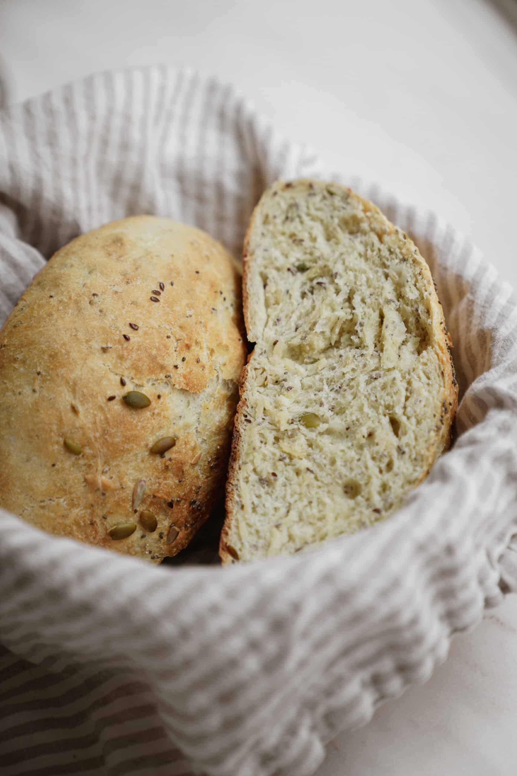 One of my fav dutch oven bread recipes for no-knead seedy bread. Bread slices in a basket.