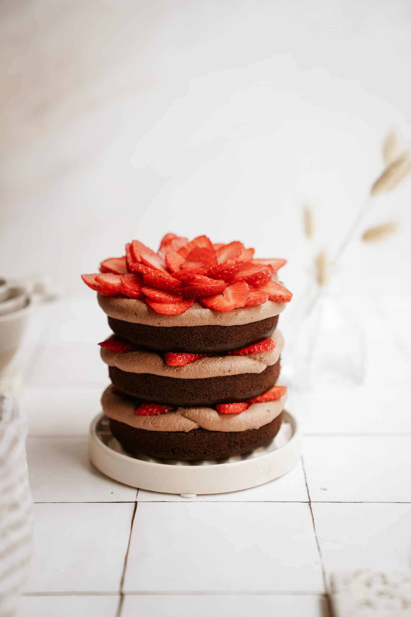 Gluten-free chocolate cake on a plate with strawberries on top