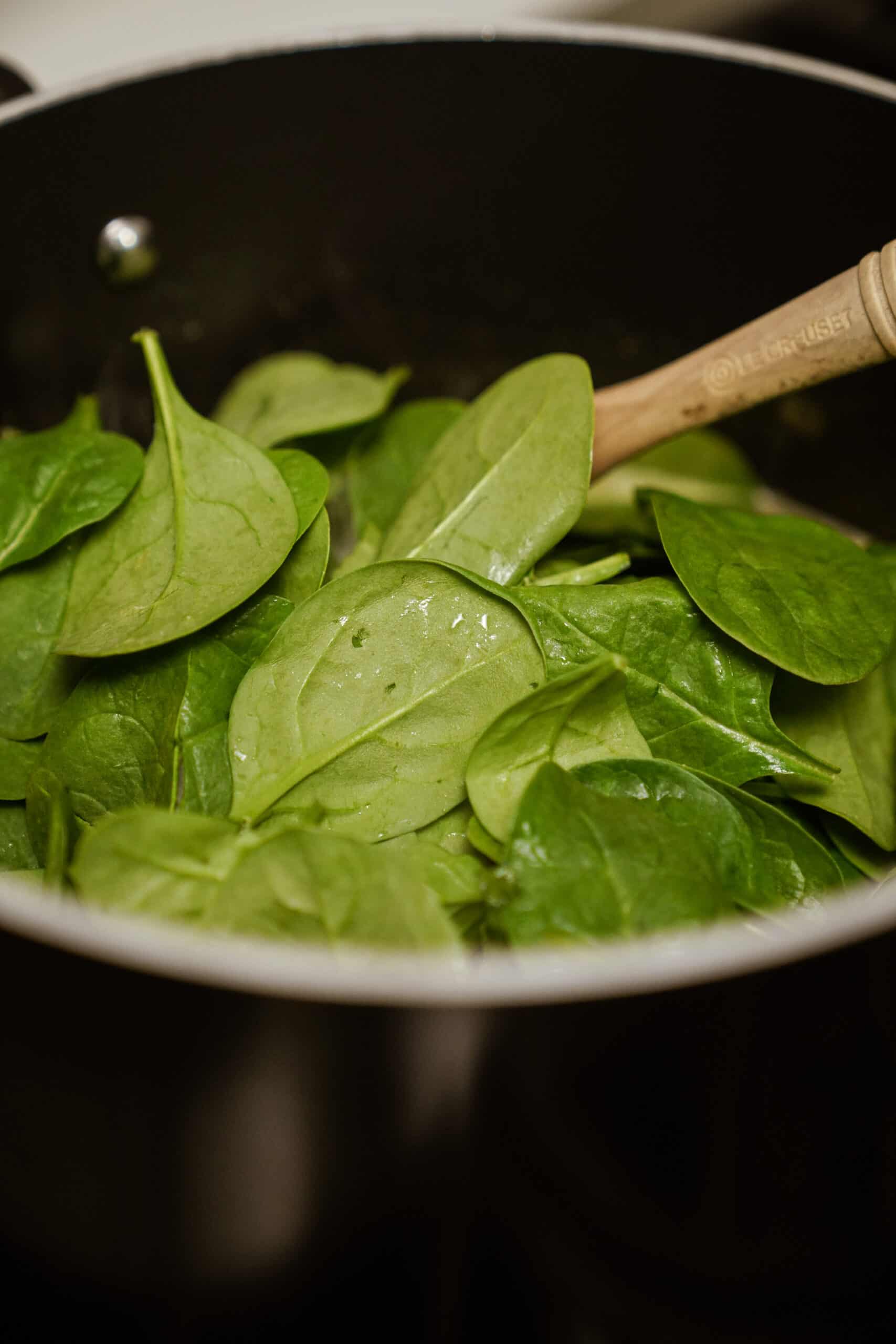 Fresh spinach added to pot for creamy noodle soup