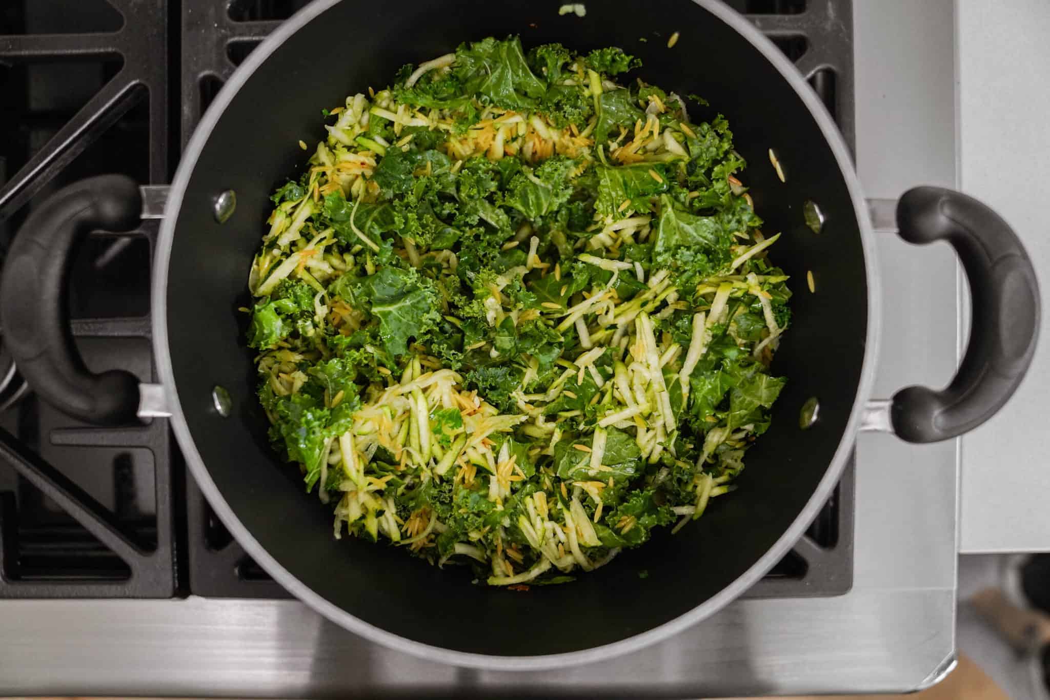 Ingredients for lemon orzo soup in a pot cooking