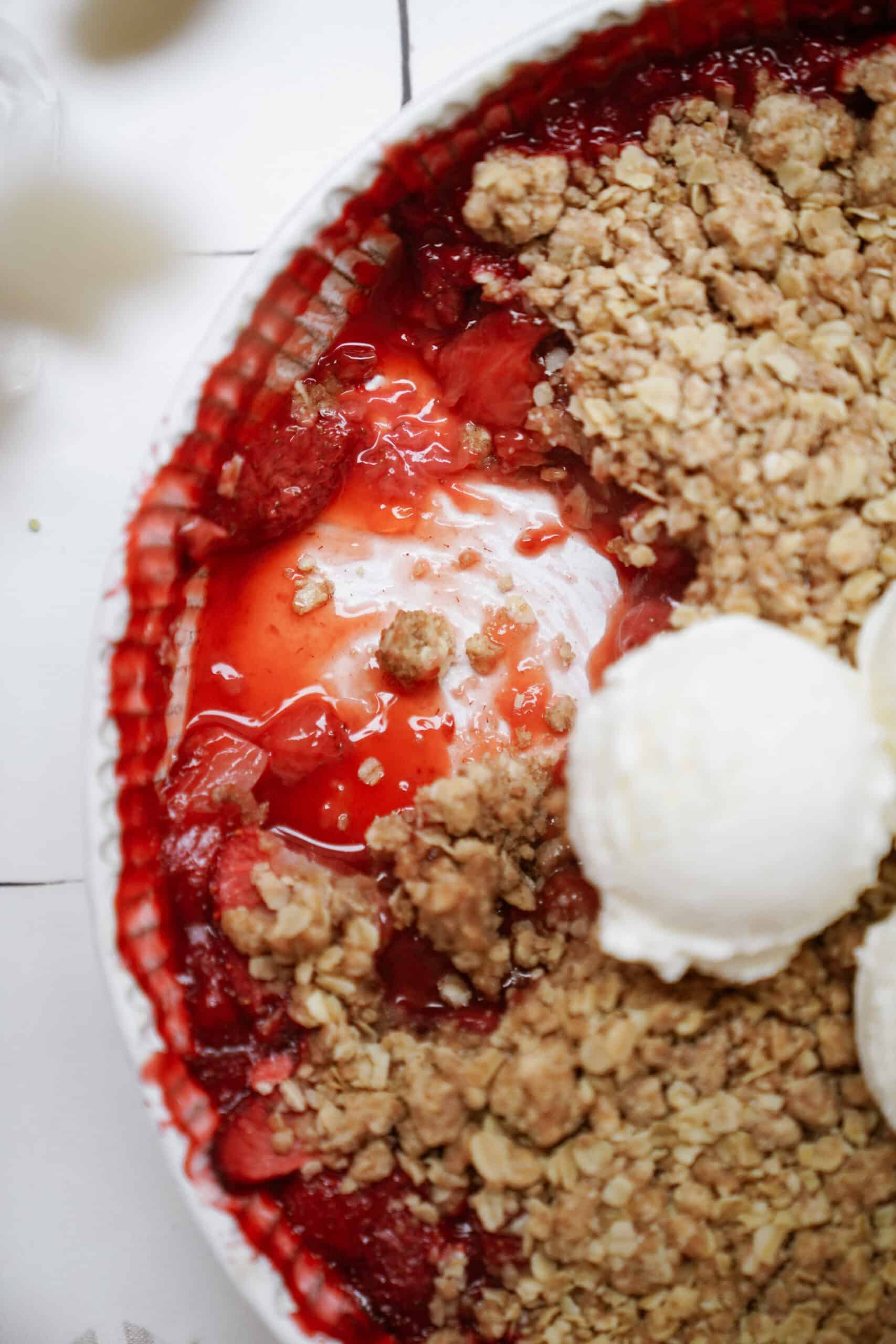 Close-up of strawberry crumble with vanilla ice cream on top