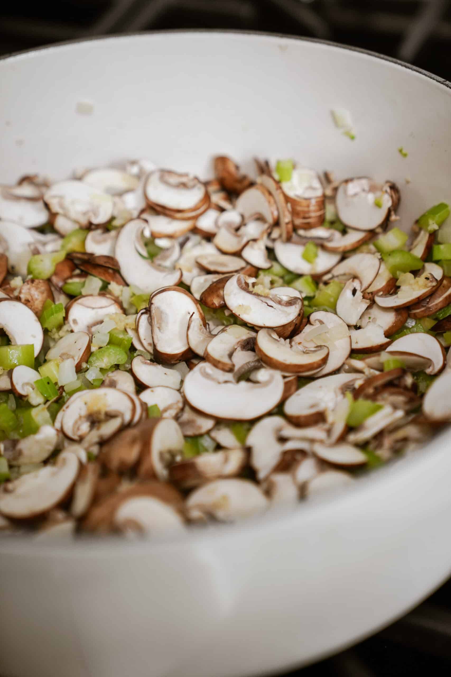 Mushrooms and veggies cooking in a pot for vegan gnocchi soup