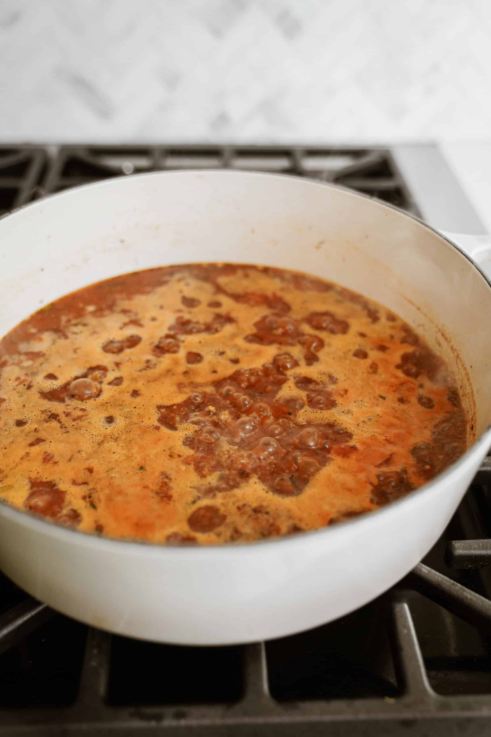 Stock being added to tortellini soup on stove