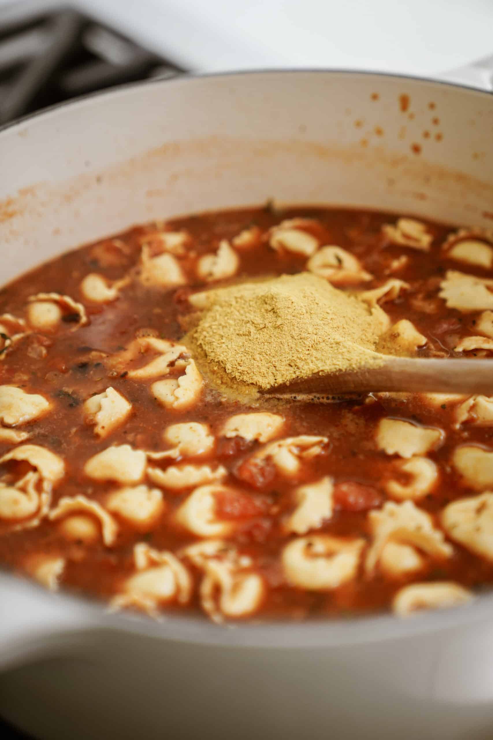 Tortellini added into pot on stove for soup