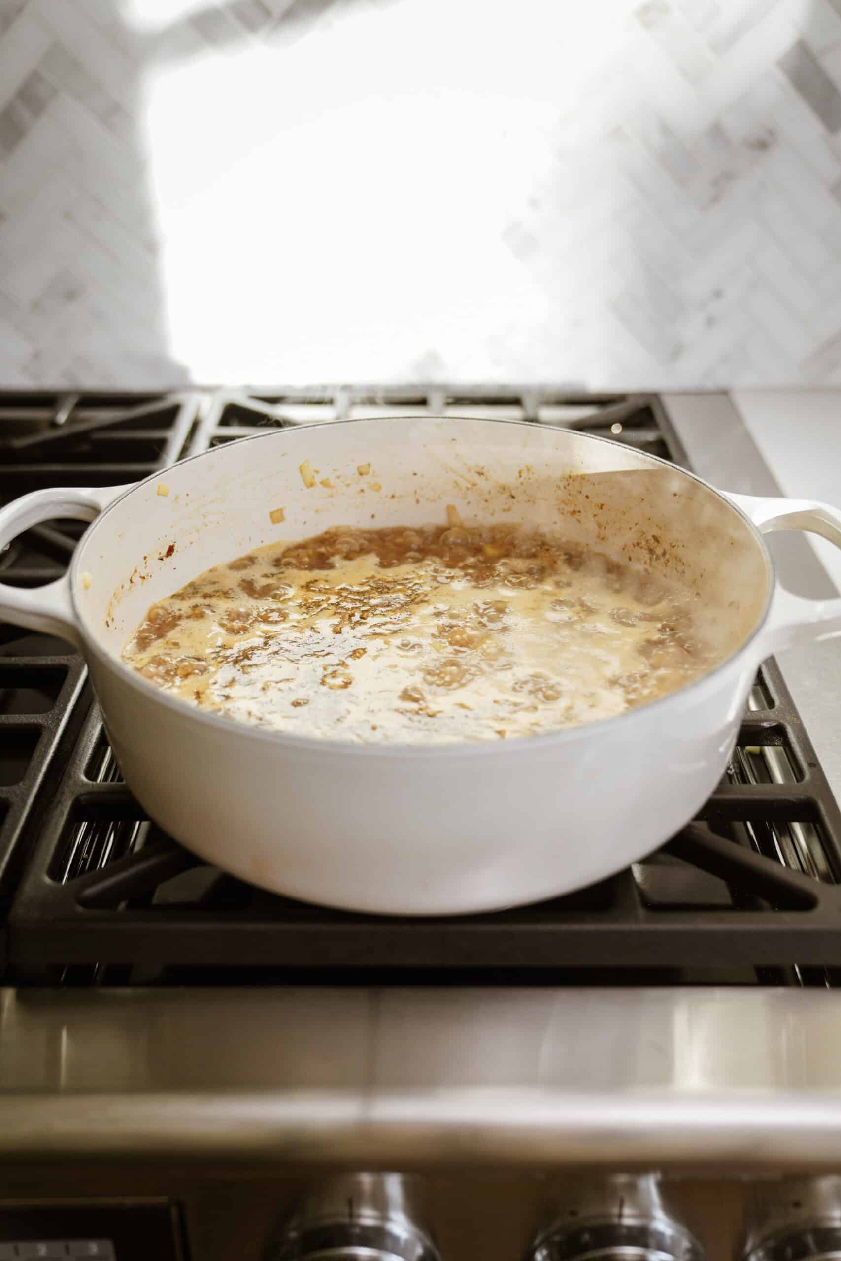 Zuppa toscana soup cooking in a pot on a stove