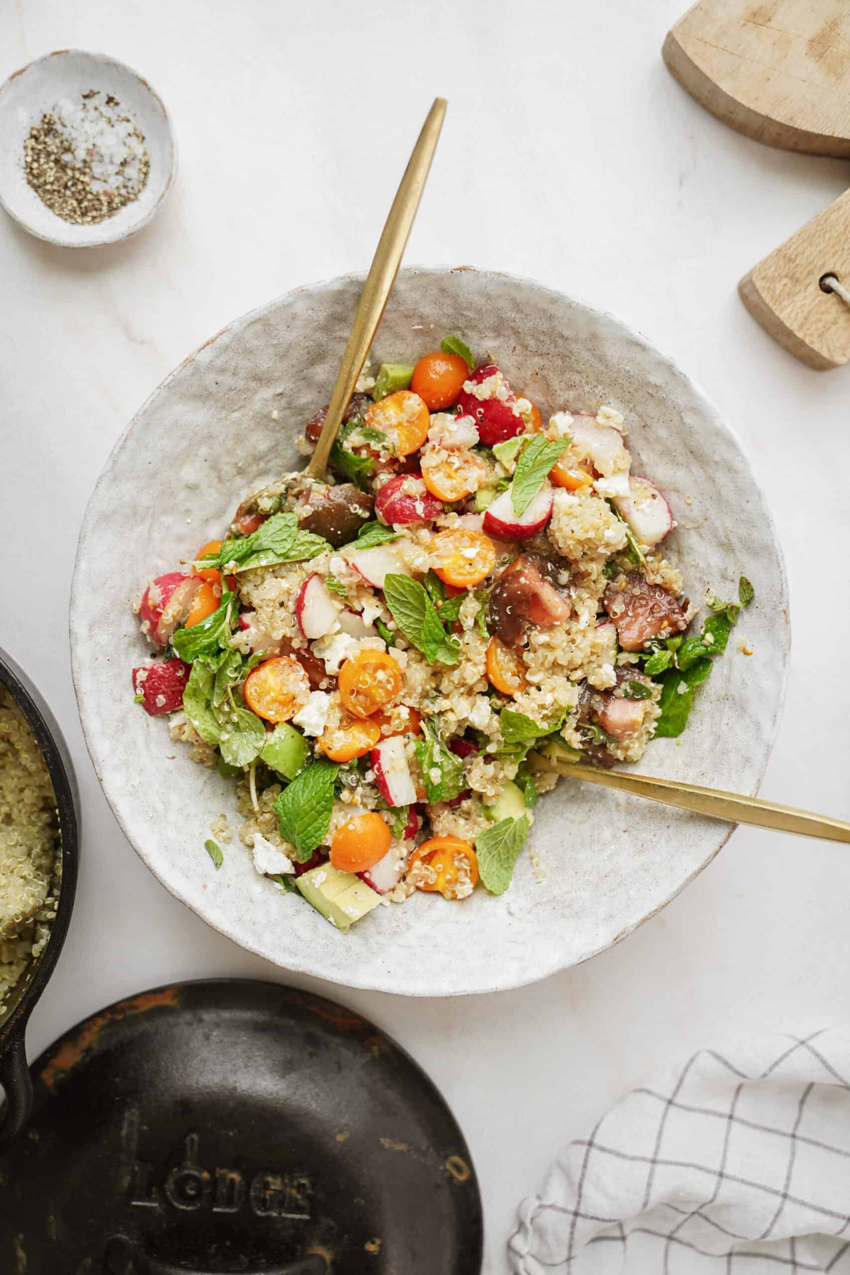 Mediterranean quinoa salad in a serving dish with serving spoons