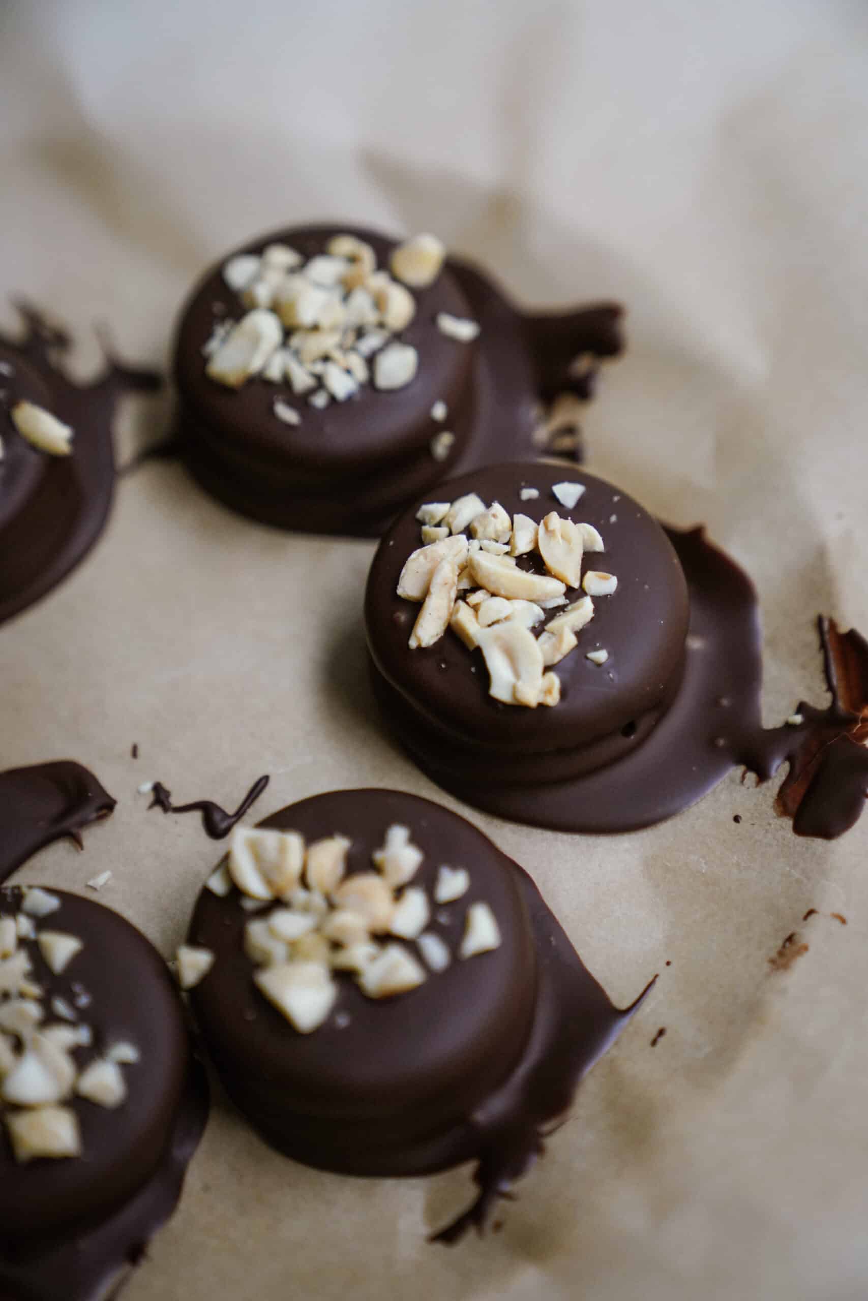 Chocolate Dipped Peanut Butter Cup Stuffed Oreos on parchment paper