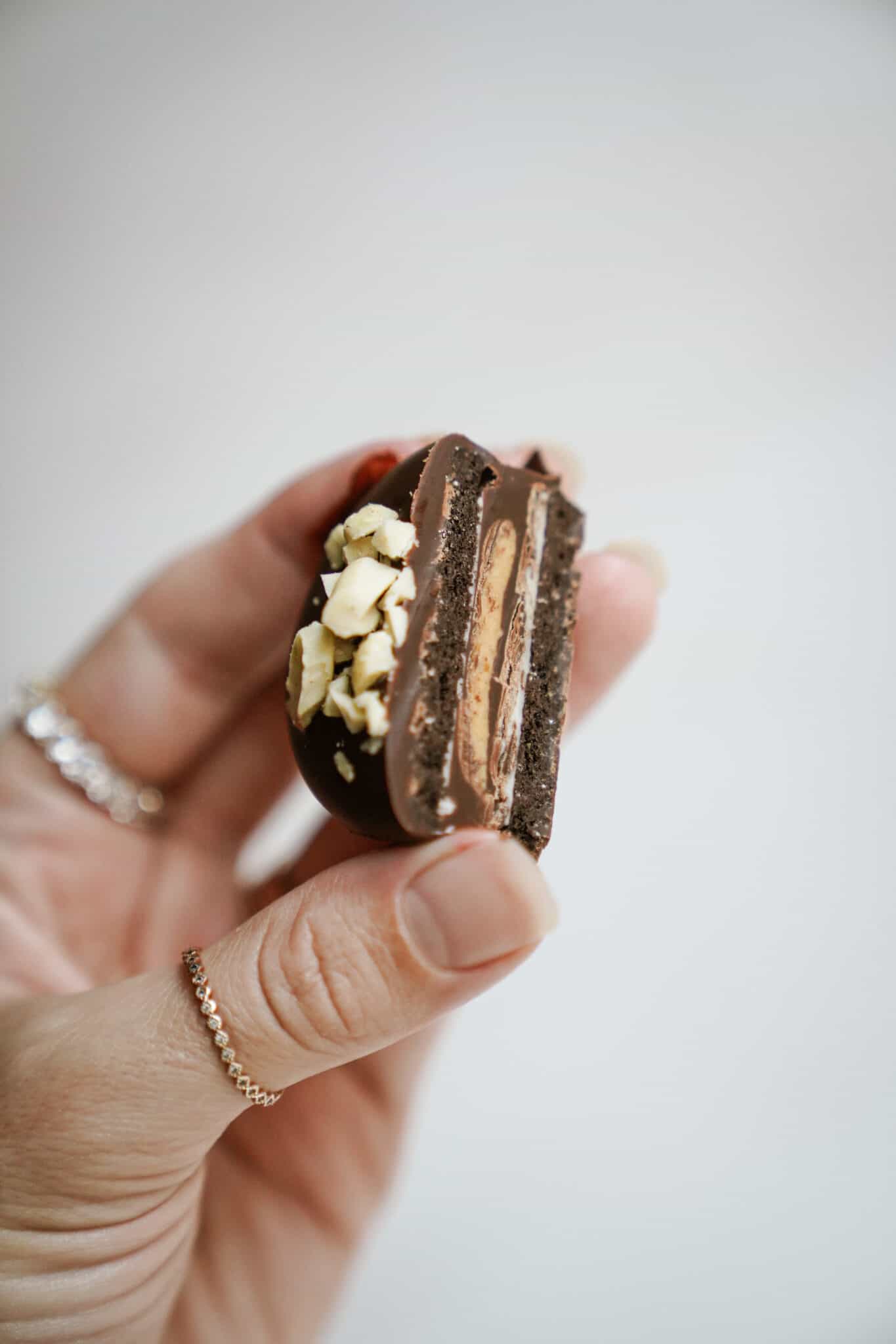 Hand holding a single Chocolate Dipped Peanut Butter Cup Stuffed Oreo