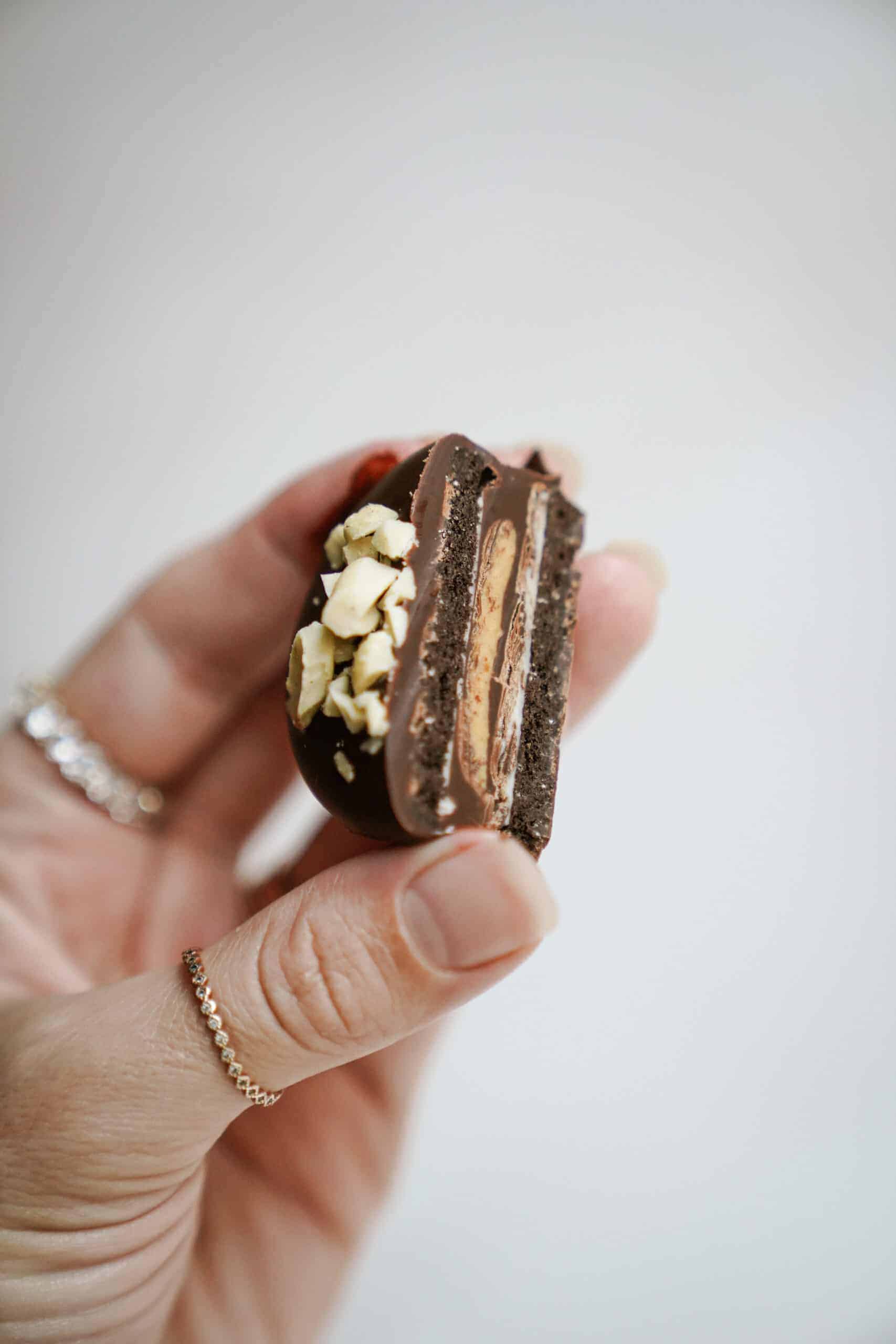 Hand holding a single Chocolate Dipped Peanut Butter Cup Stuffed Oreo