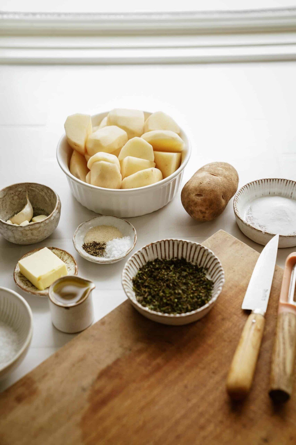 Crispy roasted potato ingredients on a counter: potatoes, butter, spices and more. 