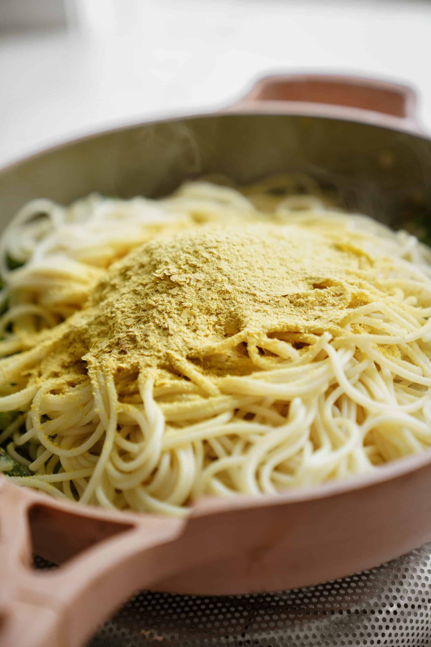 Pasta in a pan with nutritional yeast on top
