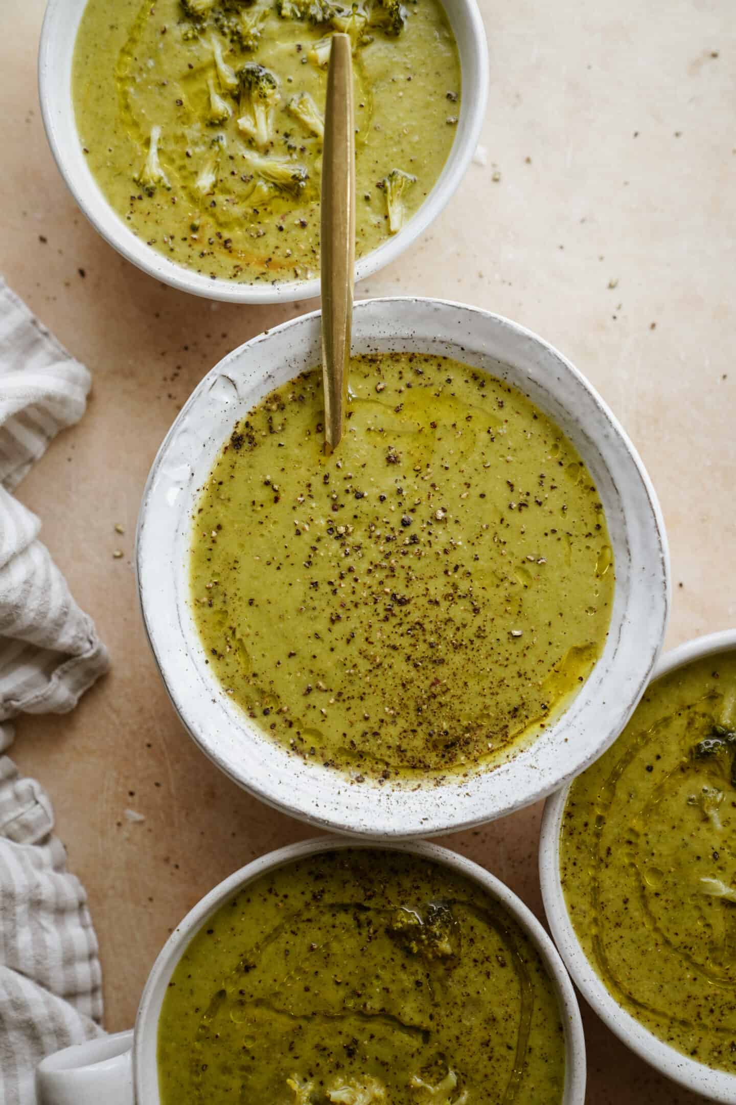 Broccoli soup in white bowls on counter