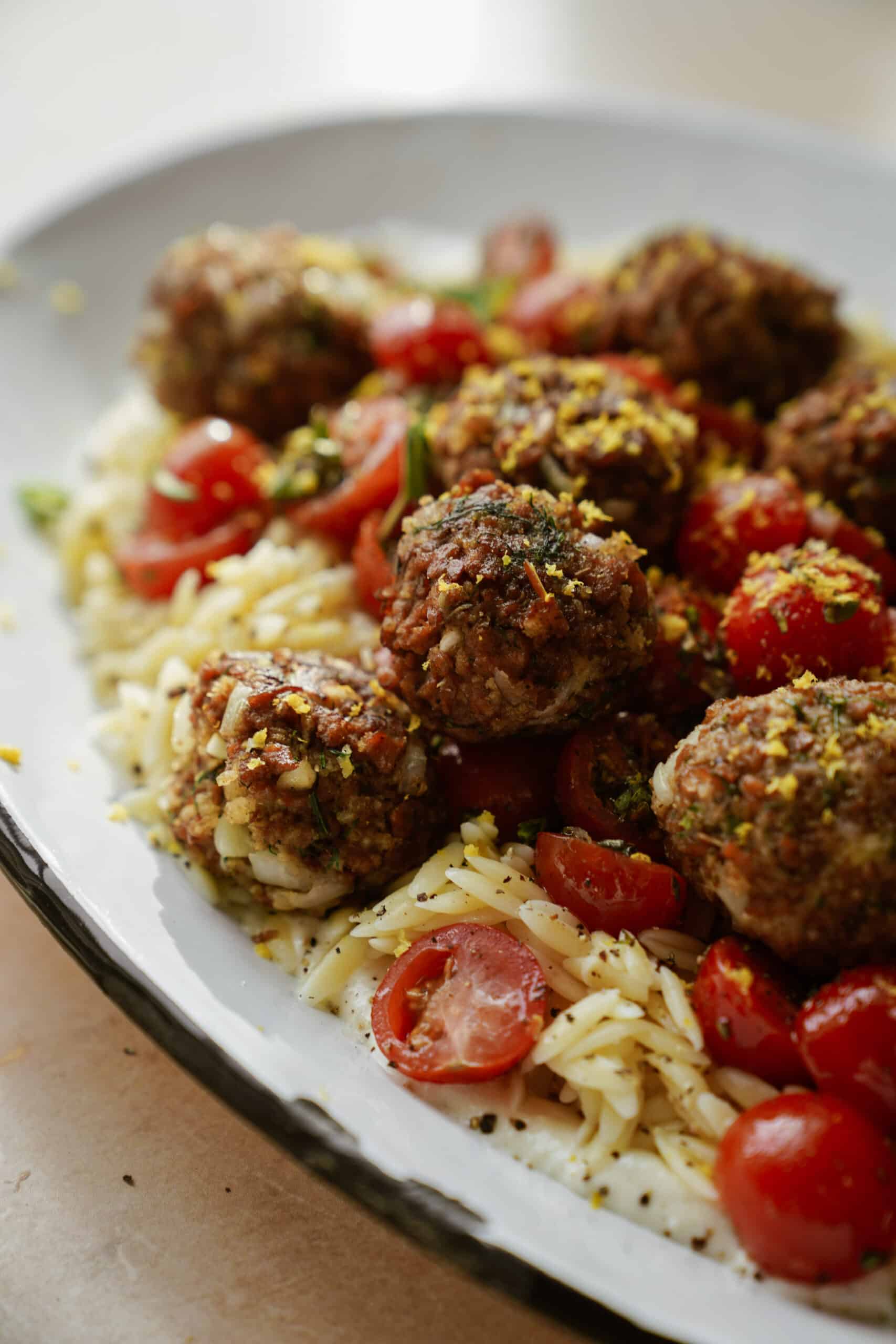 Vegan greek meatballs close-up with creamy orzo