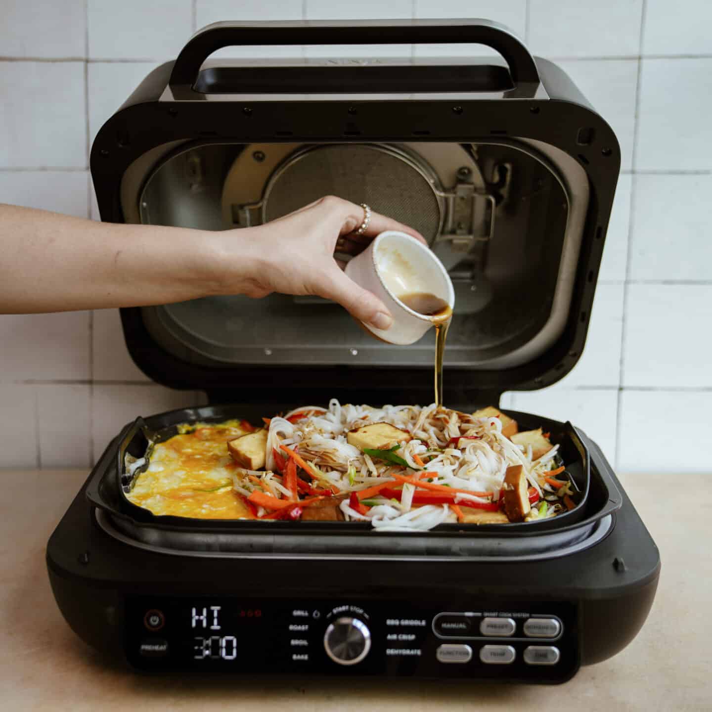 Ingredients being added to a grill for easy pad thai recipe