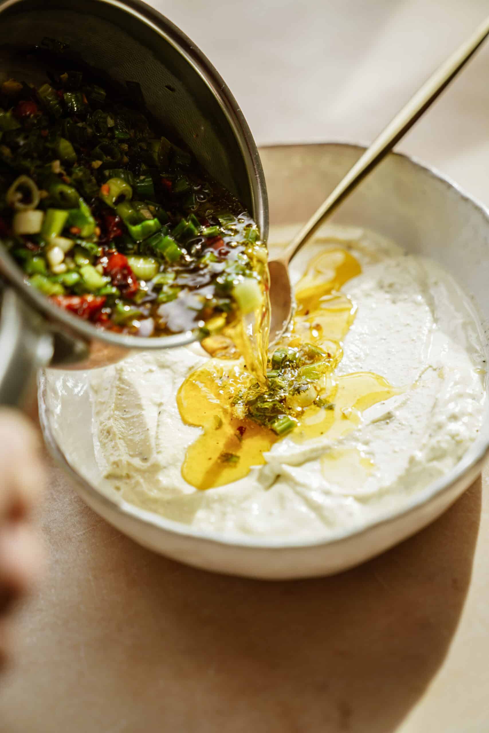 Pouring ingredients onto whipped feta