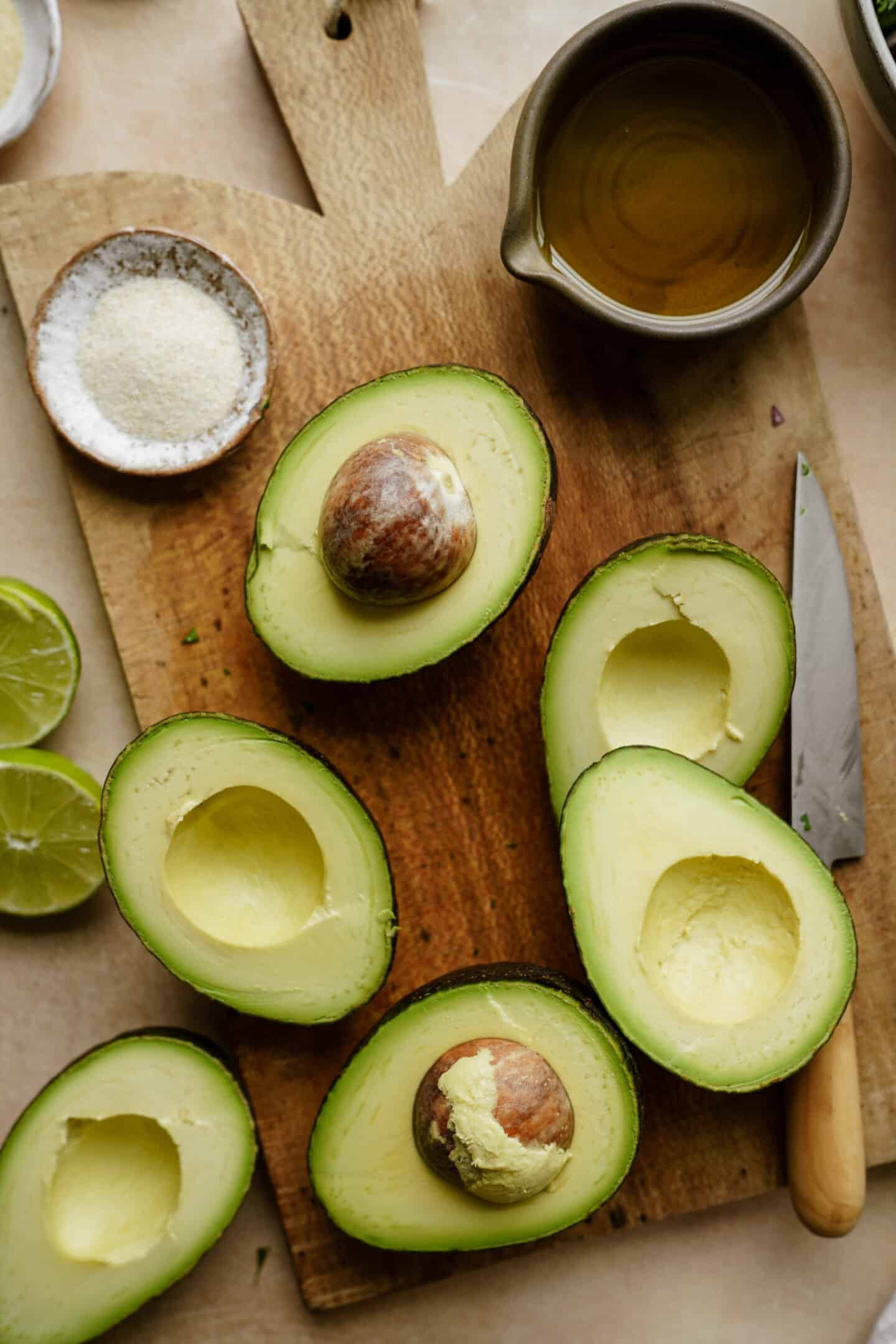 Learn how to make guacamole with me - photo of avocados cut in half on a cutting board