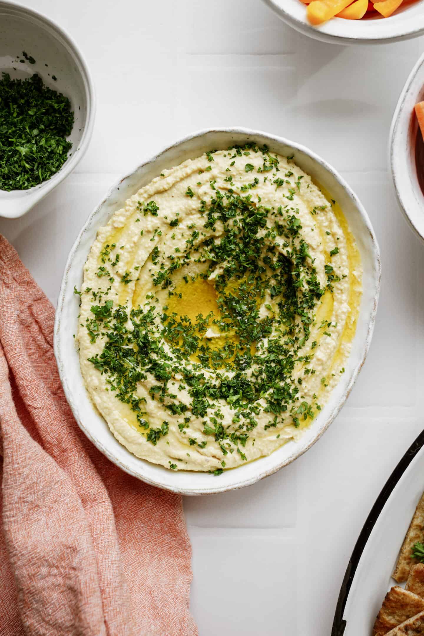 Fresh homemade hummus in a white bowl on a counter