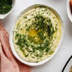 Fresh homemade hummus in a white bowl on a counter