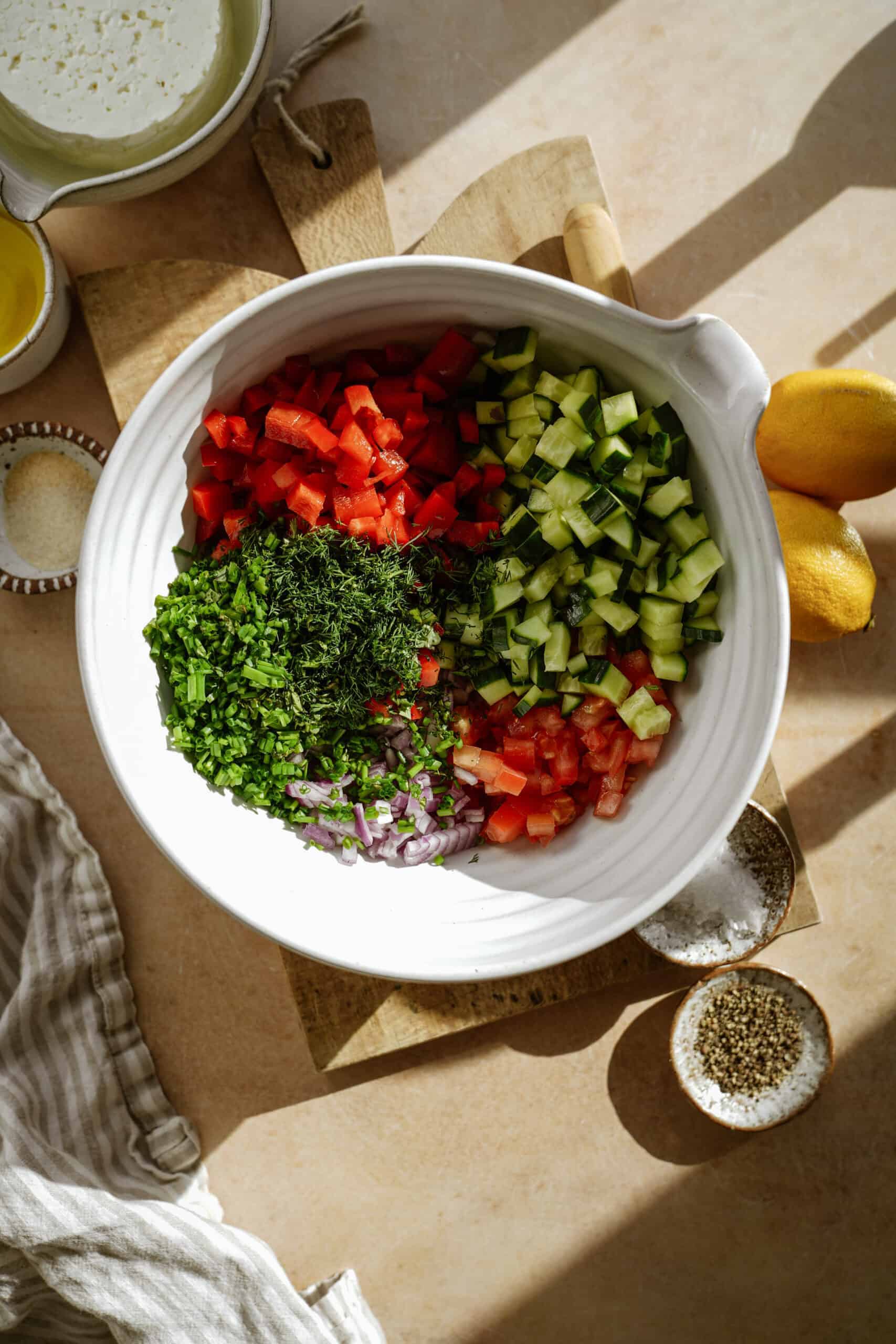 Fresh, chopped ingredients for lentil salad in a big white serving bowl