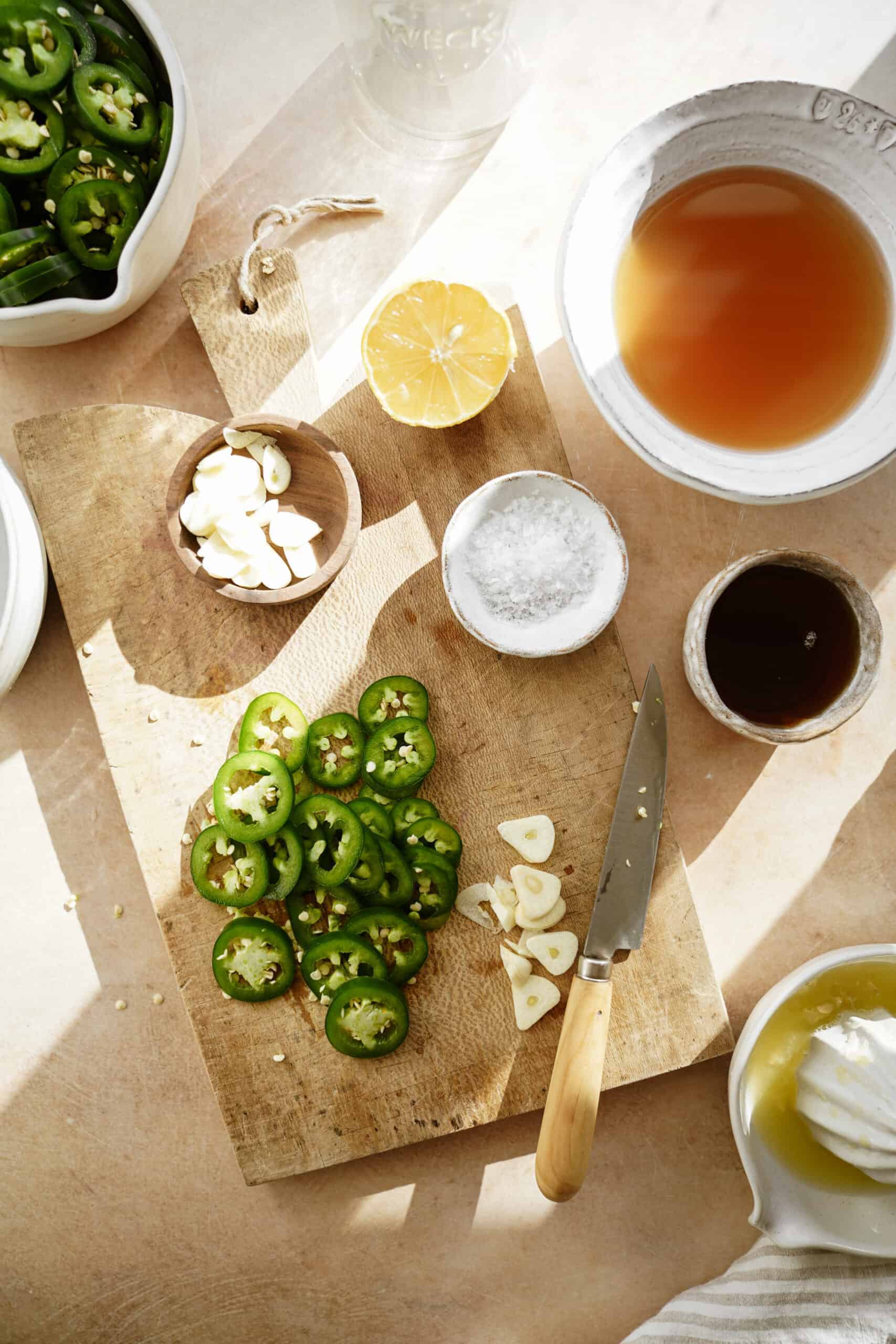 Fresh ingredients for pickled jalapenos on cutting board