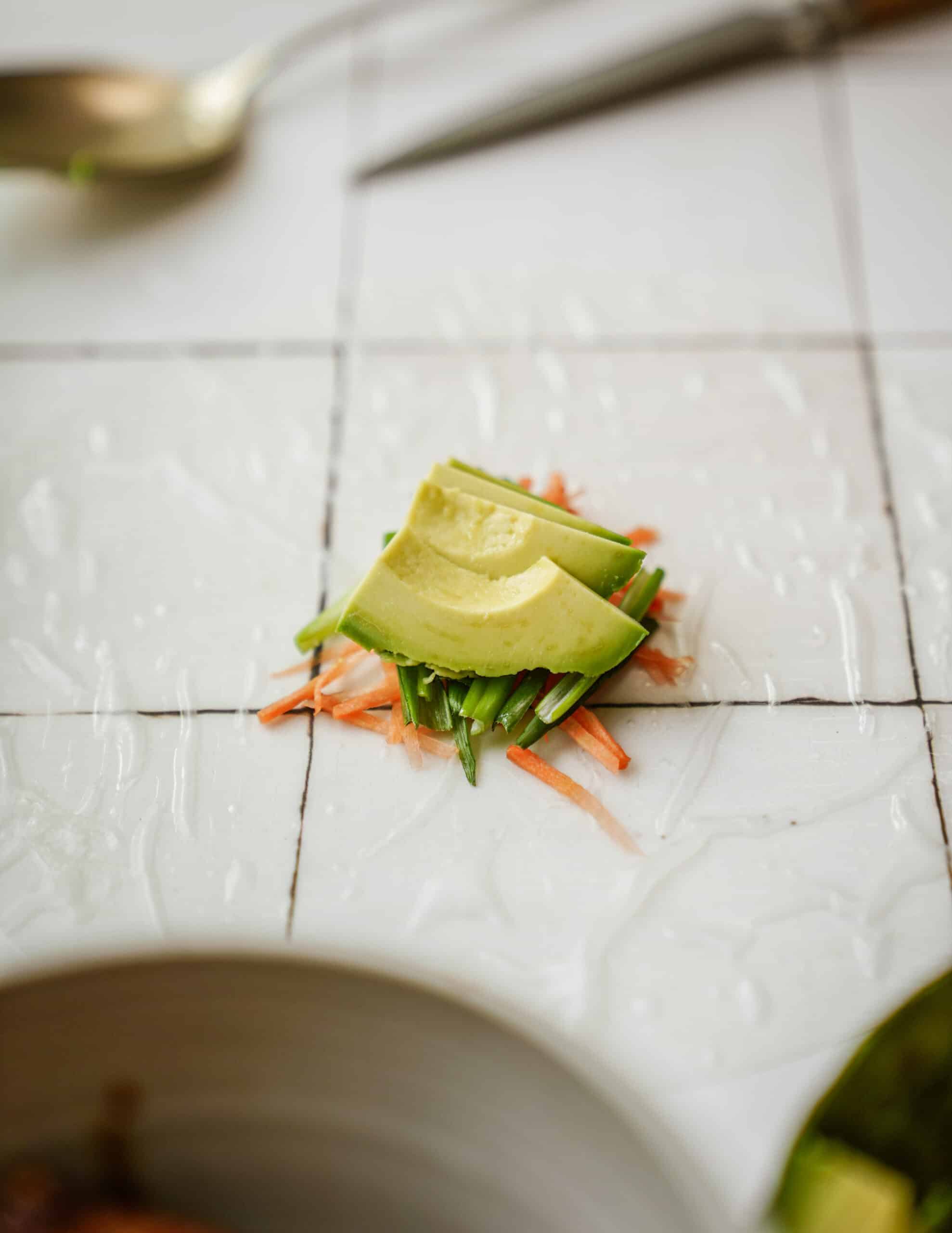 green onion, avocado and carrots on wet rice paper