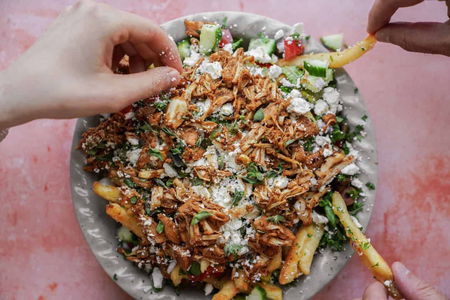 Hand taking a gyro fry off the plate