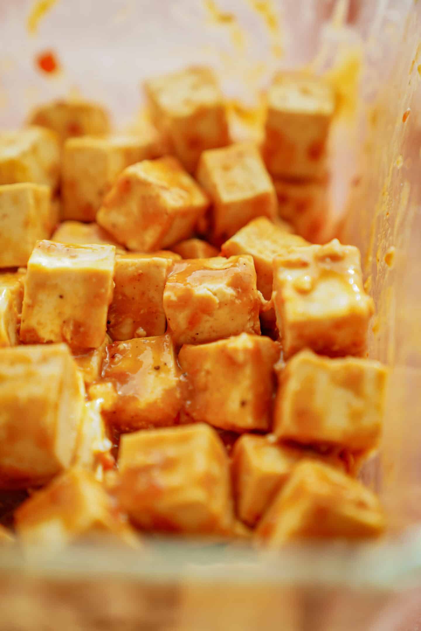 Close up of tofu marinates in a container