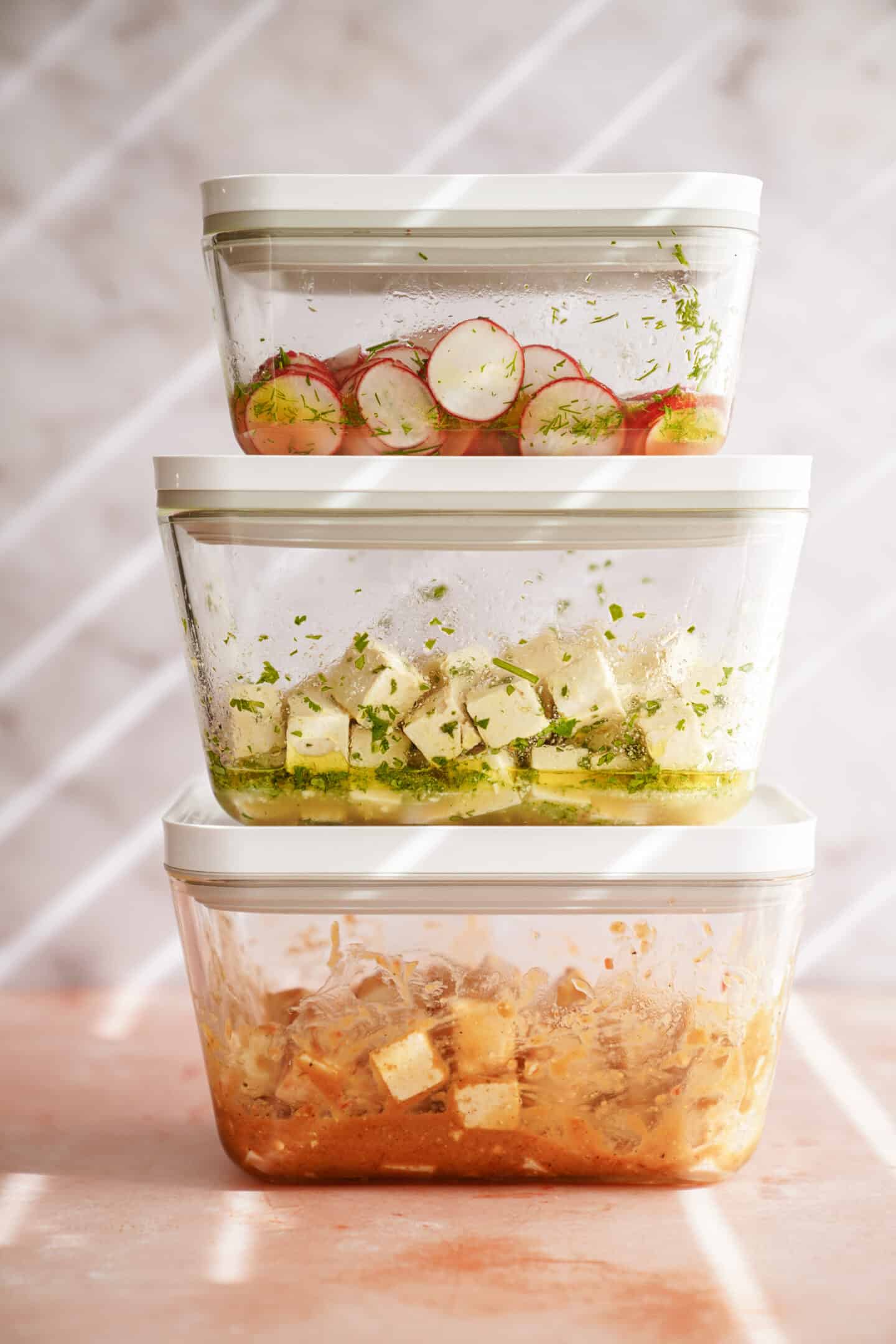 Tofu marinating in containers with veggies